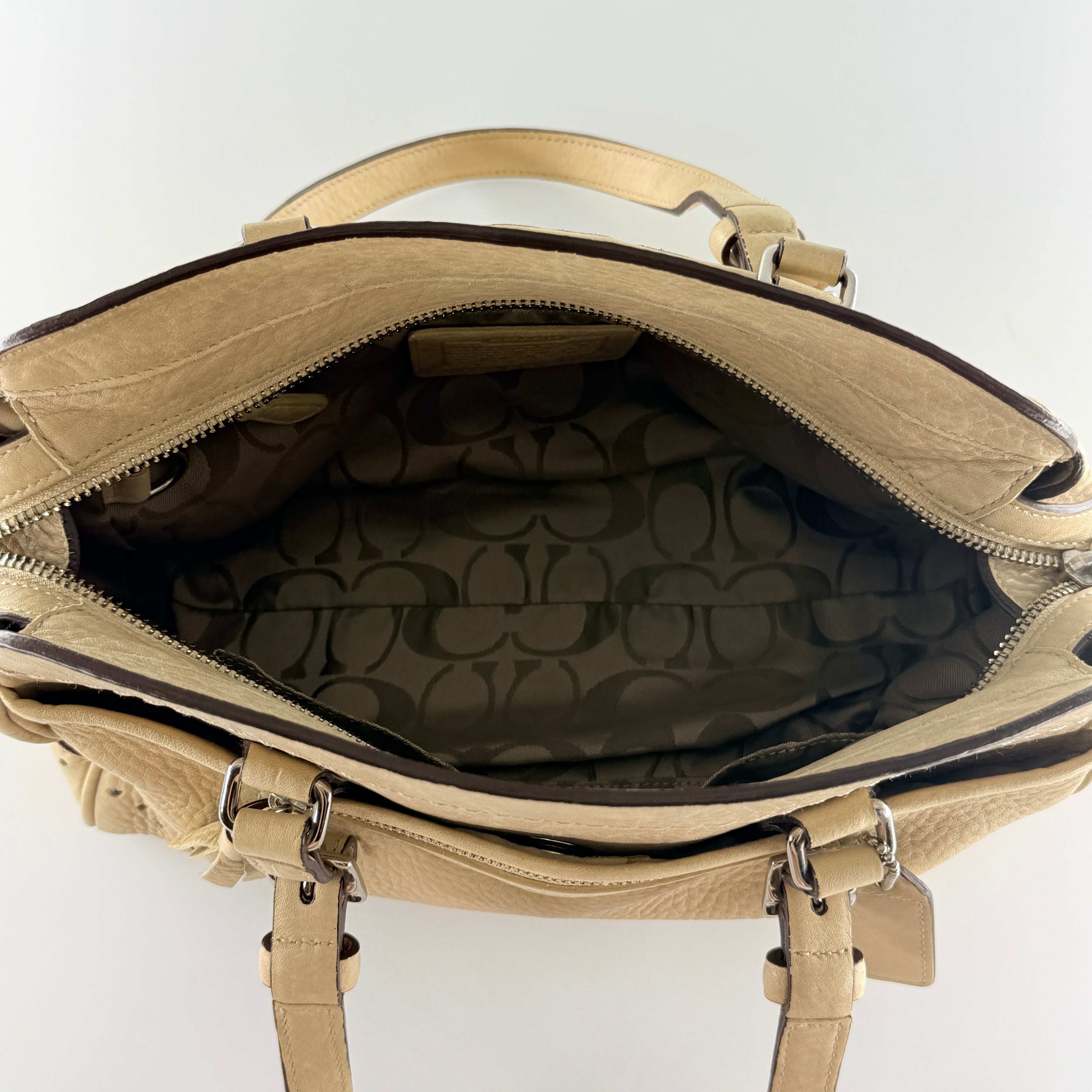 Coach Hampton Sand Satchel in beige pebbled leather with structured dual handles, front zip pocket, and silver-tone hardware.