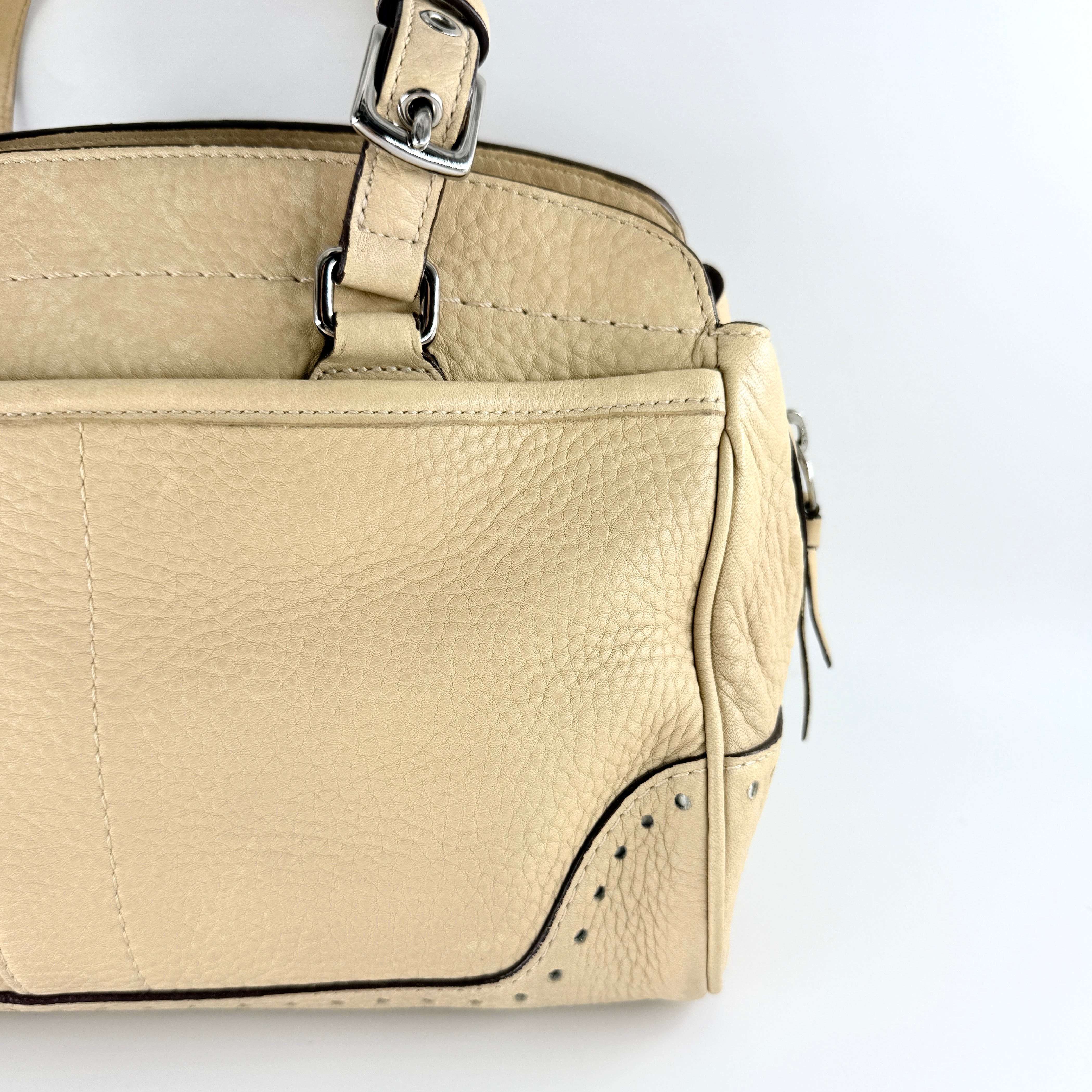 Coach Hampton Sand Satchel in beige pebbled leather with structured dual handles, front zip pocket, and silver-tone hardware.