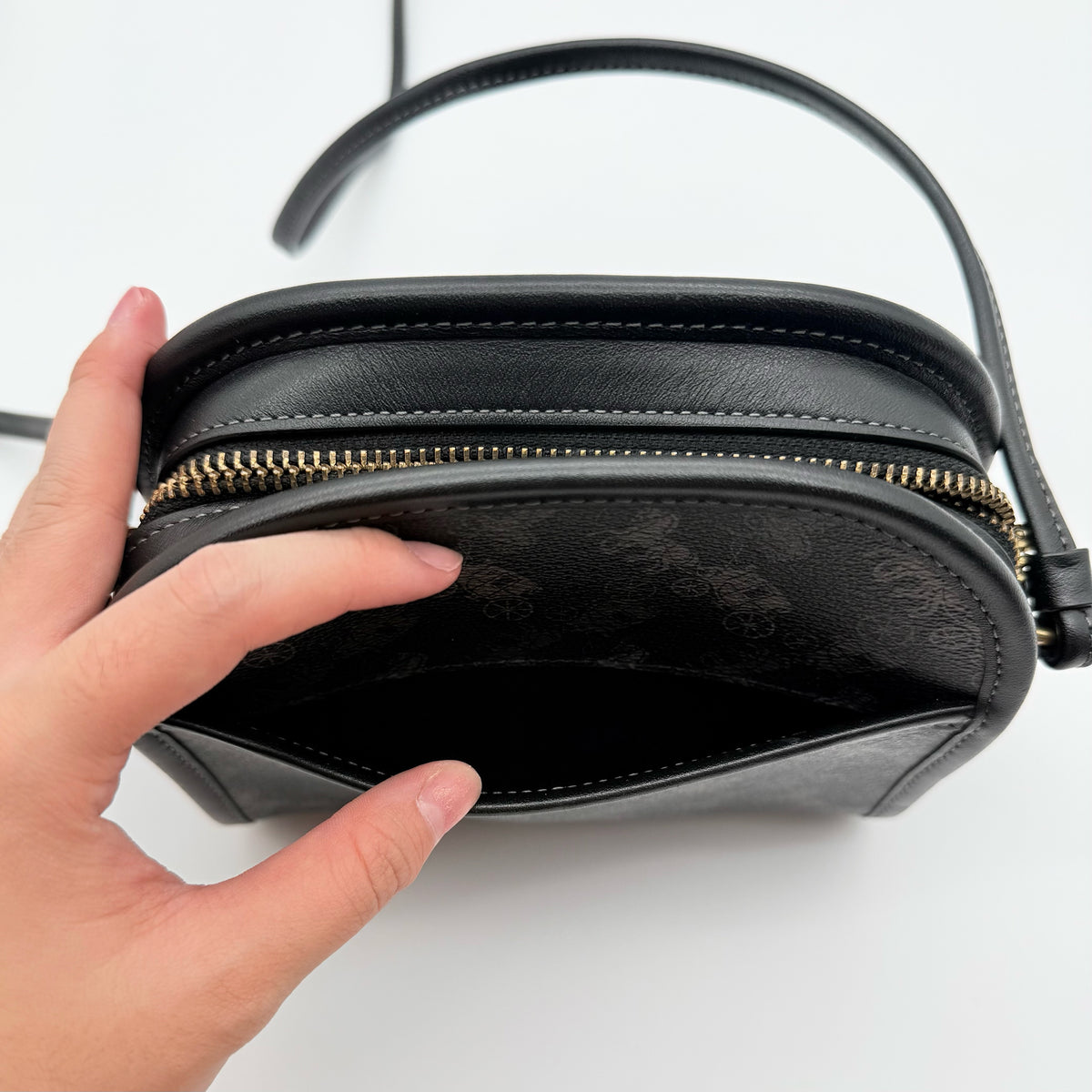 Coach Horse & Carriage Print Zip Crossbody Bag in black coated canvas with adjustable strap and gold hardware.