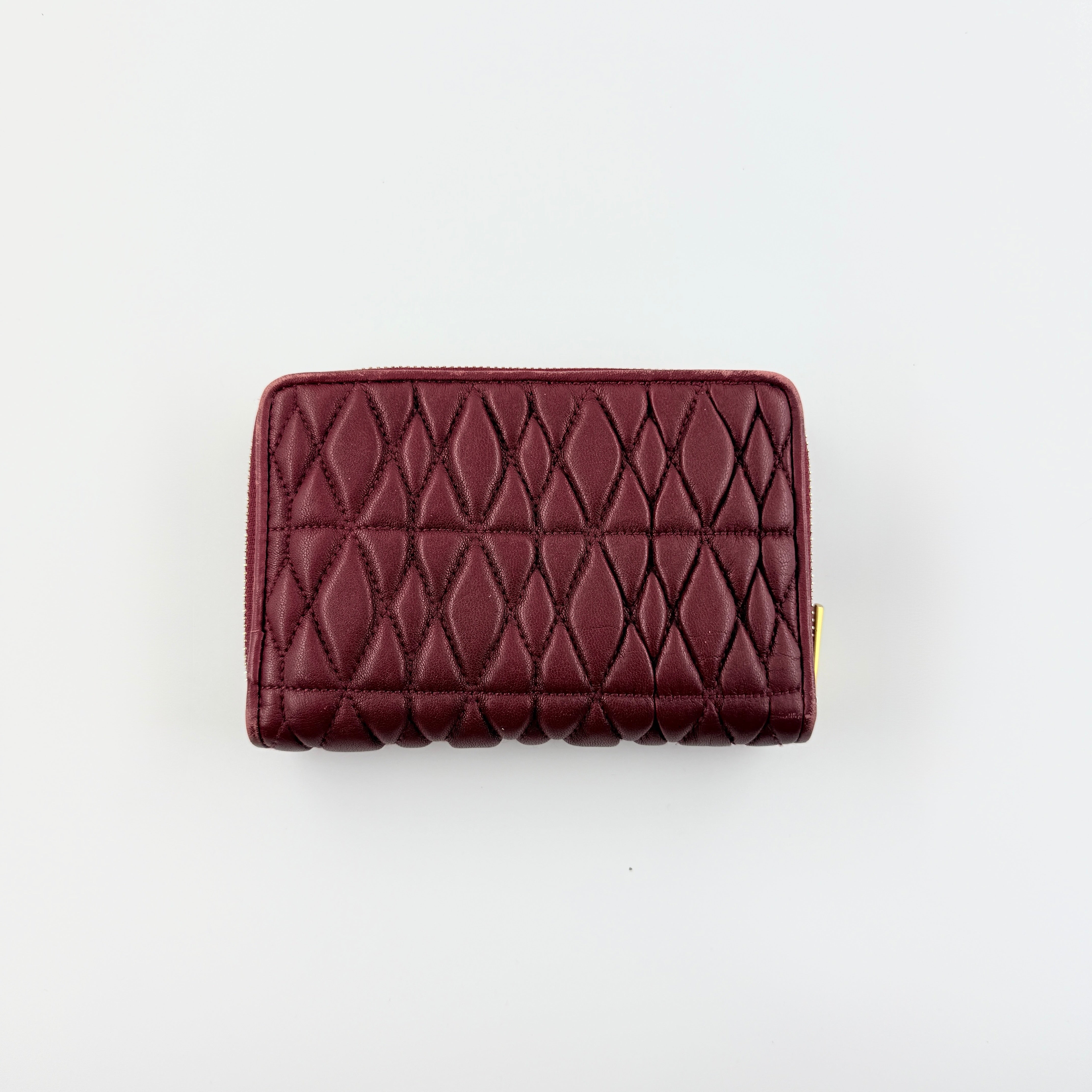 Furla quilted Cometa zip around wallet in deep burgundy leather with gold-tone hardware and diamond stitching.