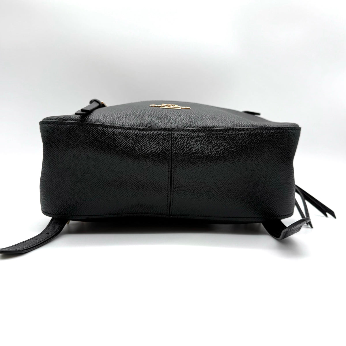 Coach Jordyn Leather Backpack in black grained leather with gold-tone hardware and minimal branding, photographed on white background.