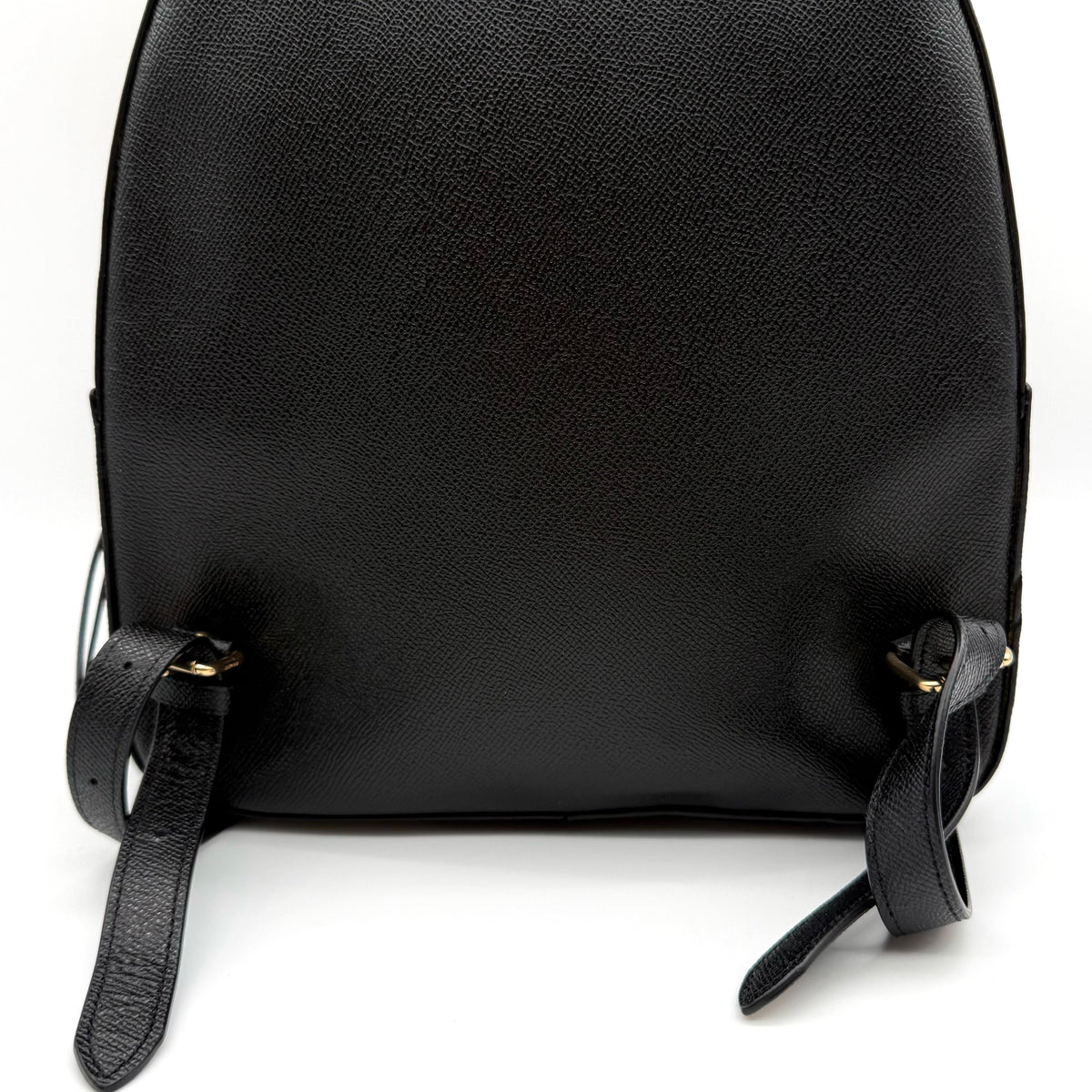 Coach Jordyn Leather Backpack in black grained leather with gold-tone hardware and minimal branding, photographed on white background.