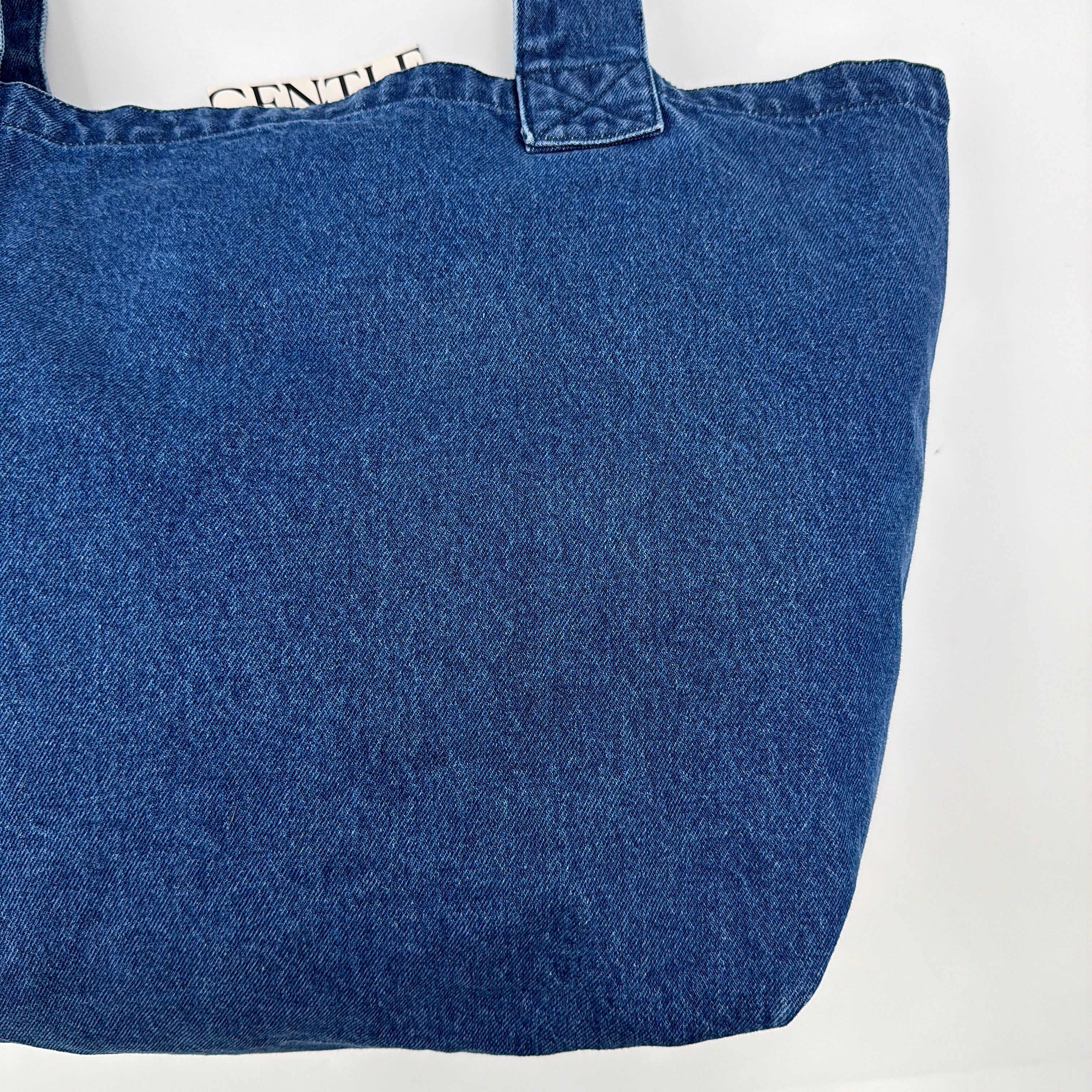 GENTLEWOMAN Jumbo Tote Bag in blue denim with oversized pale blue monogram, featuring sturdy twin handles.