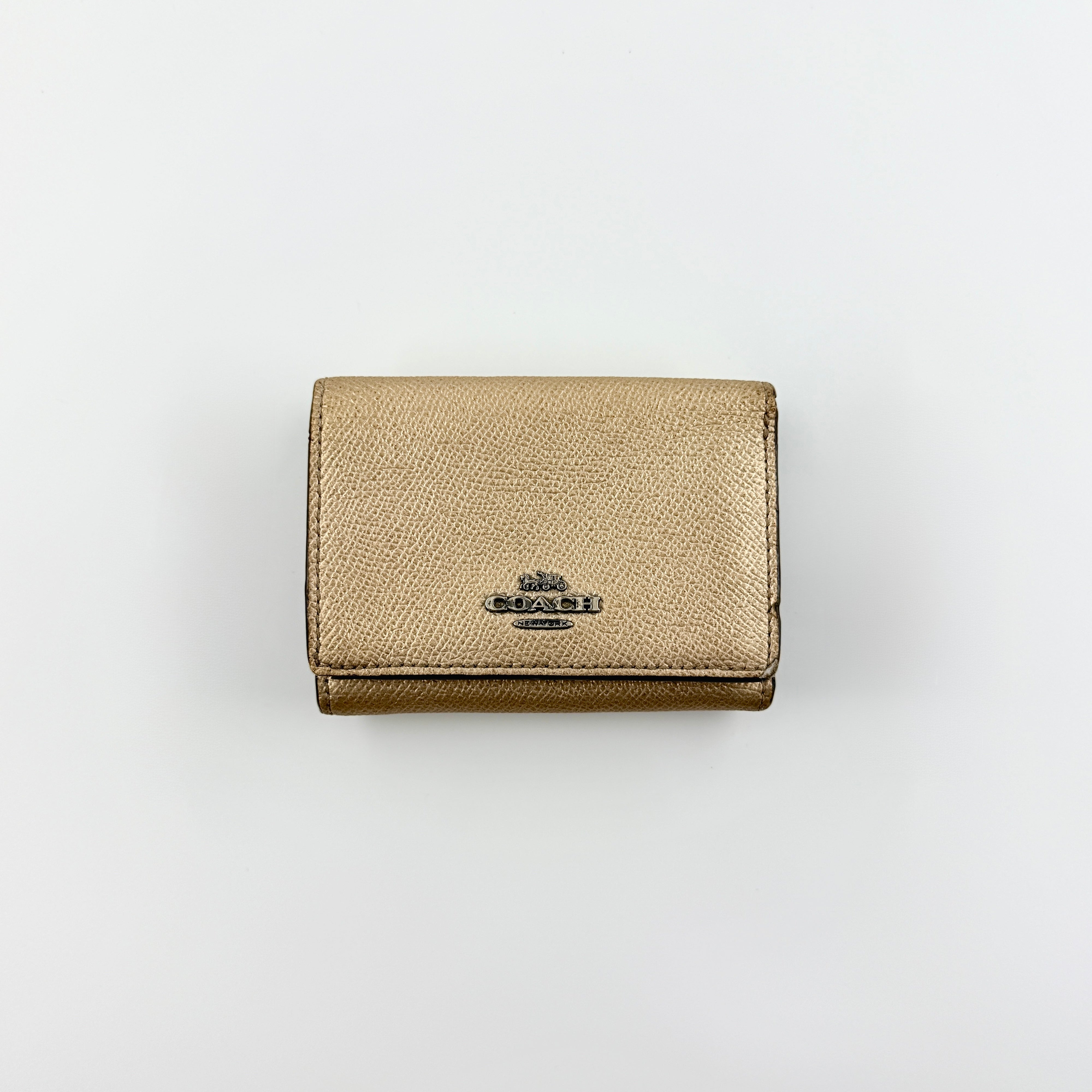 Coach metallic gold small flap wallet with silver logo plaque and crosshatch textured leather.
