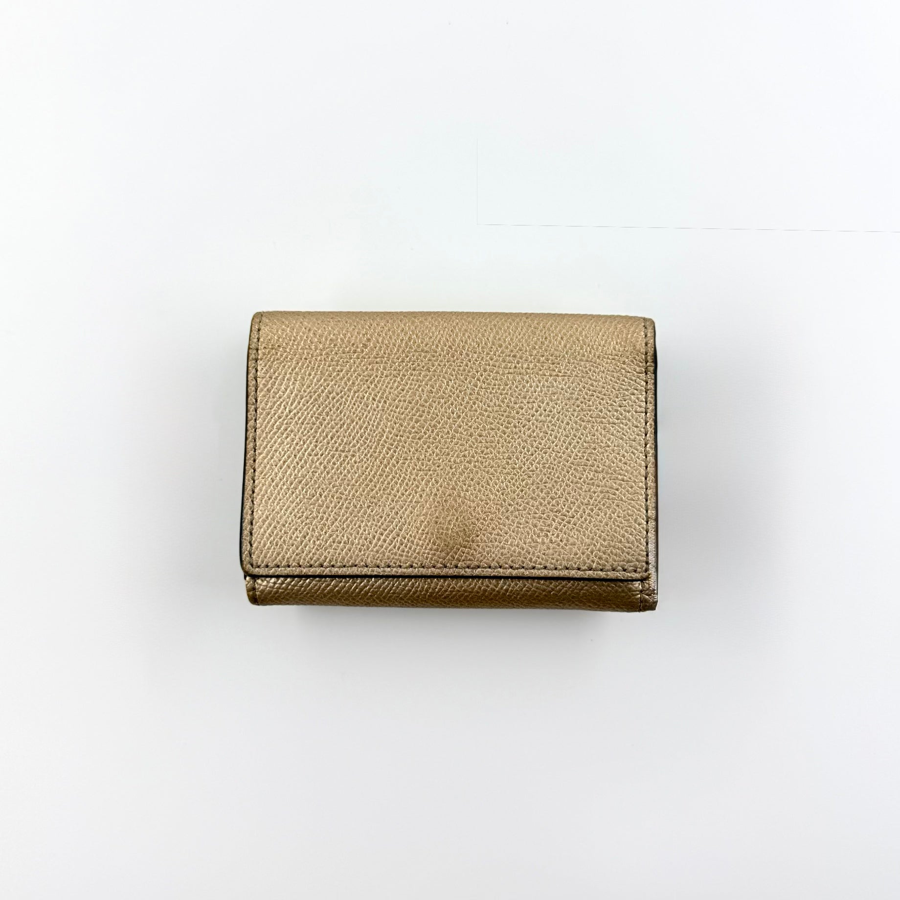 Coach metallic gold small flap wallet with silver logo plaque and crosshatch textured leather.