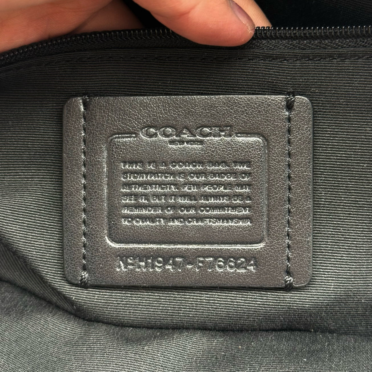 Coach Jordyn Leather Backpack in black grained leather with gold-tone hardware and minimal branding, photographed on white background.