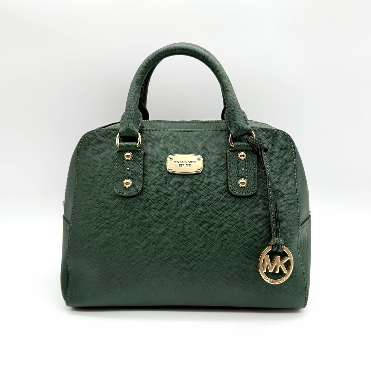 Michael Kors dark green Saffiano leather dome satchel with gold hardware and detachable strap, shown against a white background.