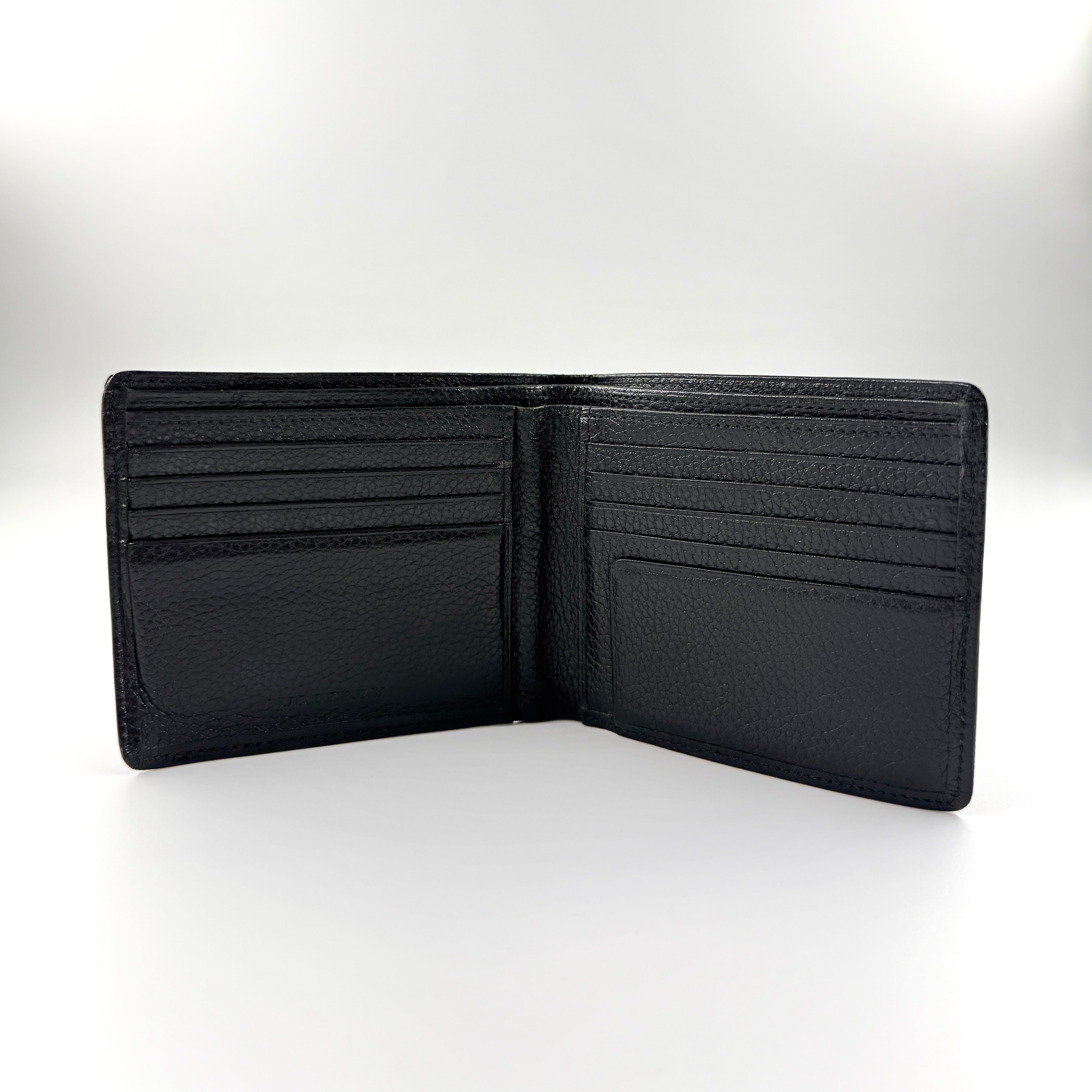 Burberry Nova Check bifold wallet in refined black grained leather with discreet embossed logo, presenting a minimal and polished silhouette.