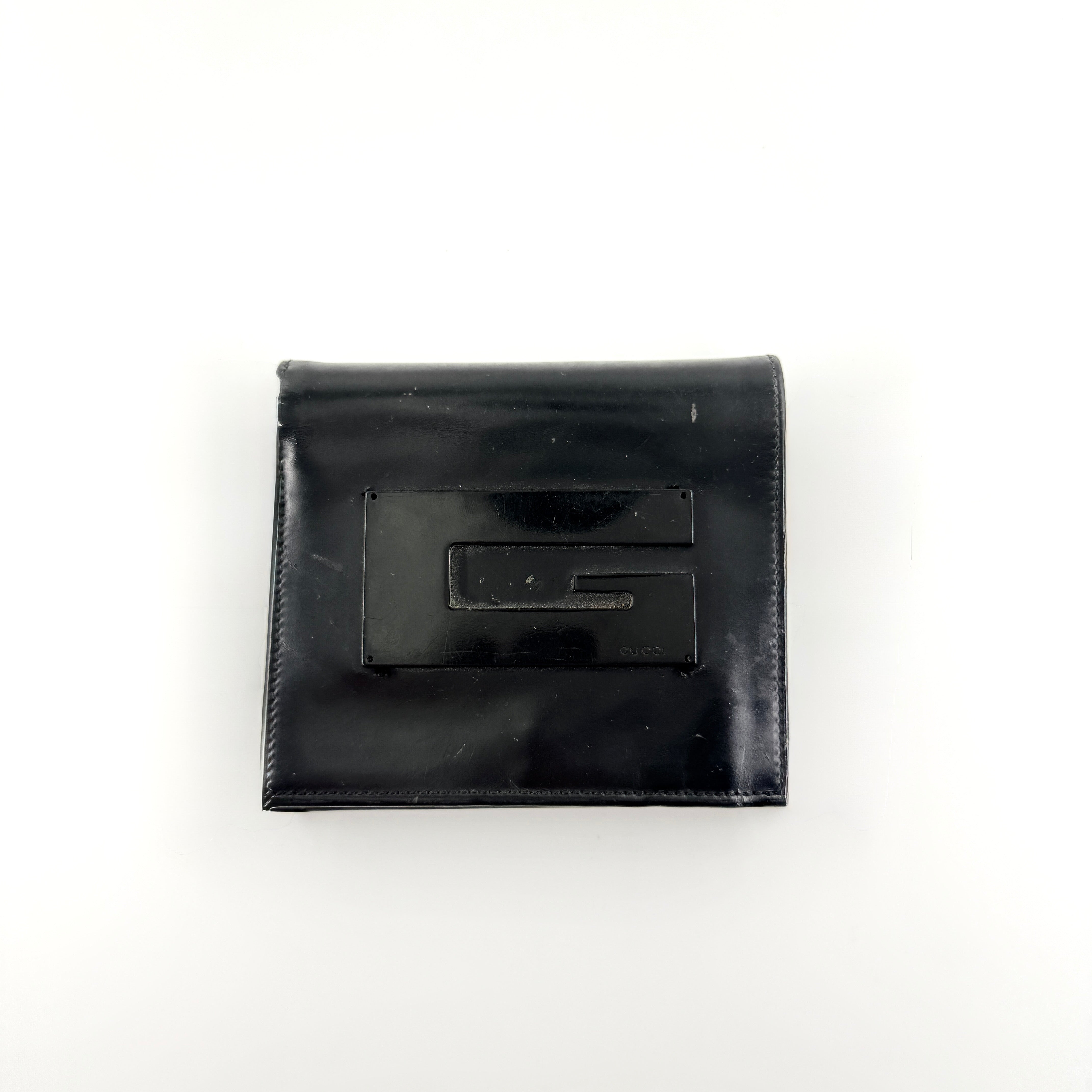 Gucci G Logo Bifold Wallet in black leather featuring a bold geometric G plaque and meticulously stitched edges.