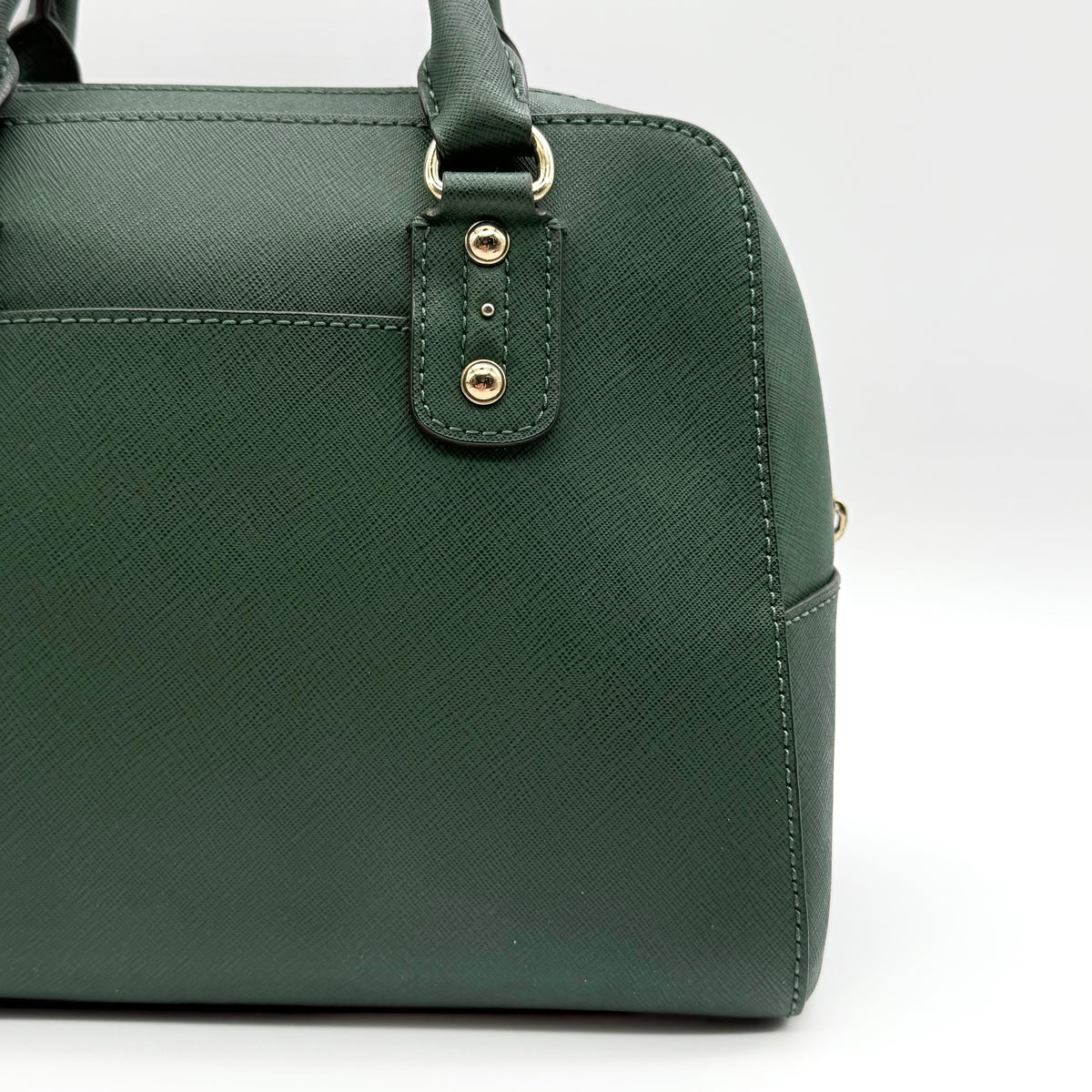 Michael Kors dark green Saffiano leather dome satchel with gold hardware and detachable strap, shown against a white background.