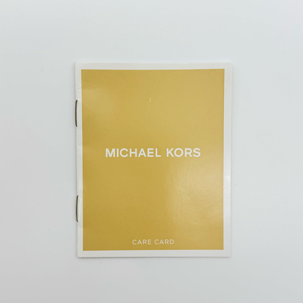 Michael Kors dark green Saffiano leather dome satchel with gold hardware and detachable strap, shown against a white background.