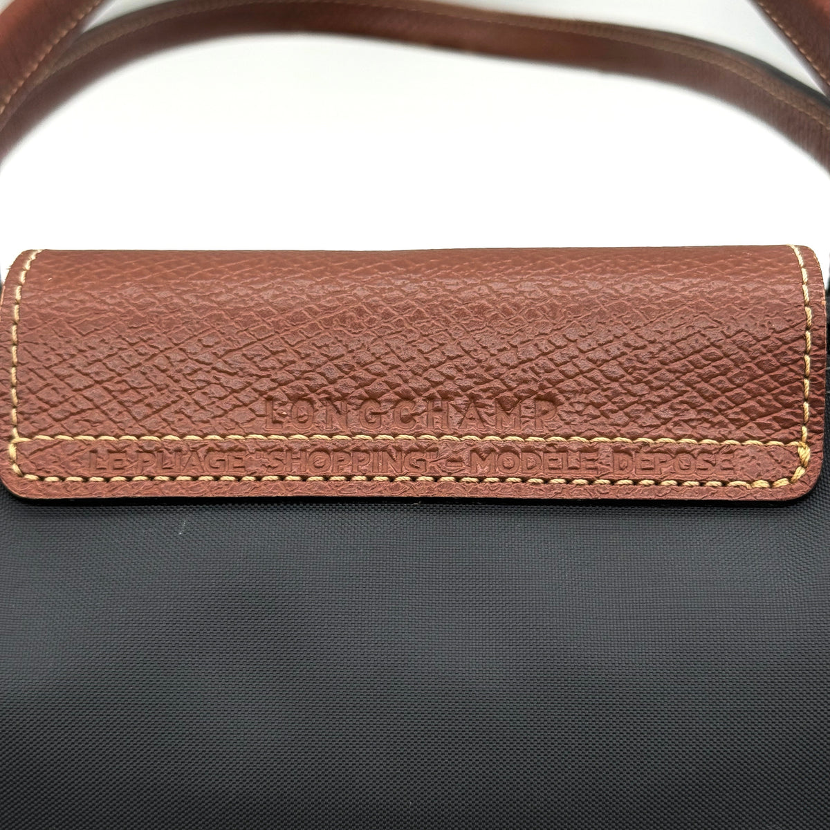 Longchamp Le Pliage Original Tote Bag in grey nylon with brown leather handles and flap, displayed against a white background.