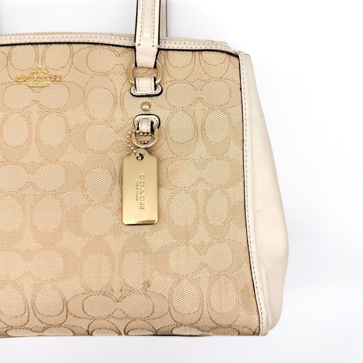 Coach Stanton Carryall in beige and ivory jacquard canvas with gold hardware and detachable strap, styled for everyday versatility.