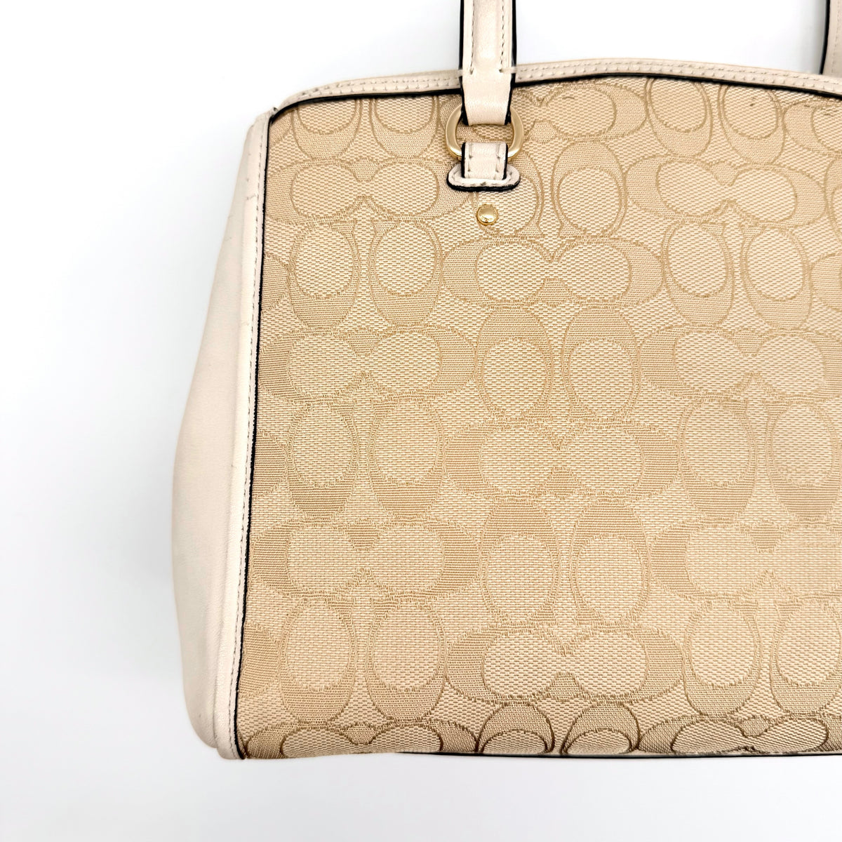 Coach Stanton Carryall in beige and ivory jacquard canvas with gold hardware and detachable strap, styled for everyday versatility.