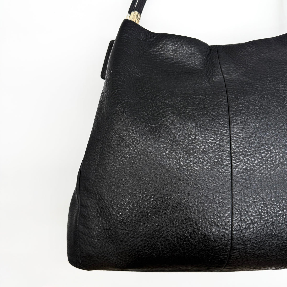 Coach Madison Phoebe Shoulder Bag in black grained leather with gold hardware and dual handles, shown against a white background.