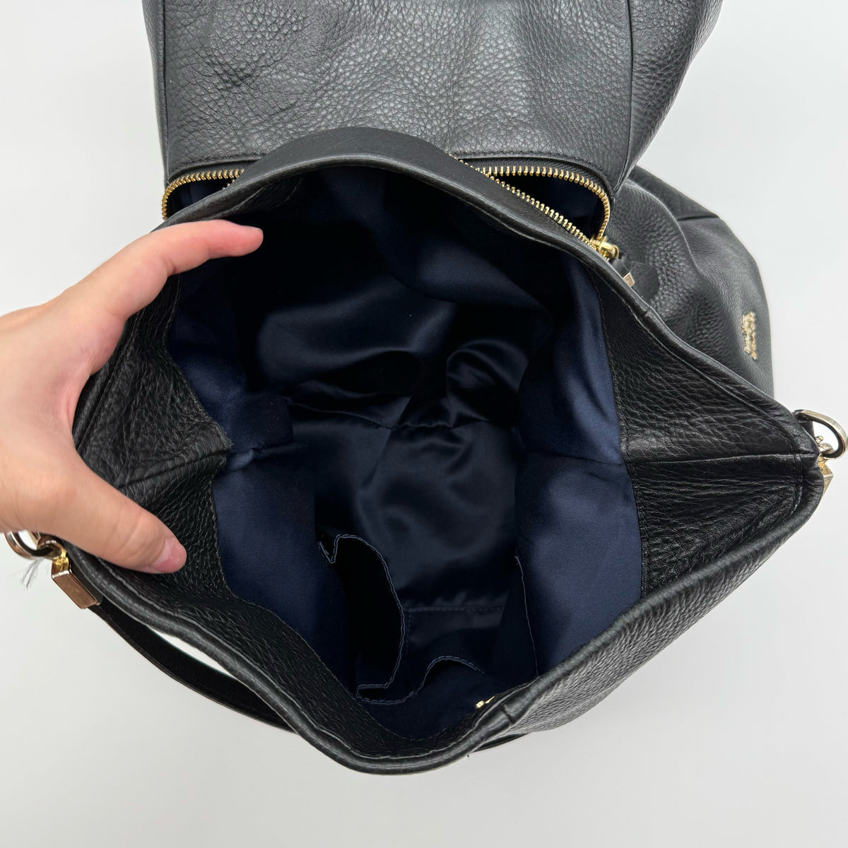 Coach Madison Phoebe Shoulder Bag in black grained leather with gold hardware and dual handles, shown against a white background.