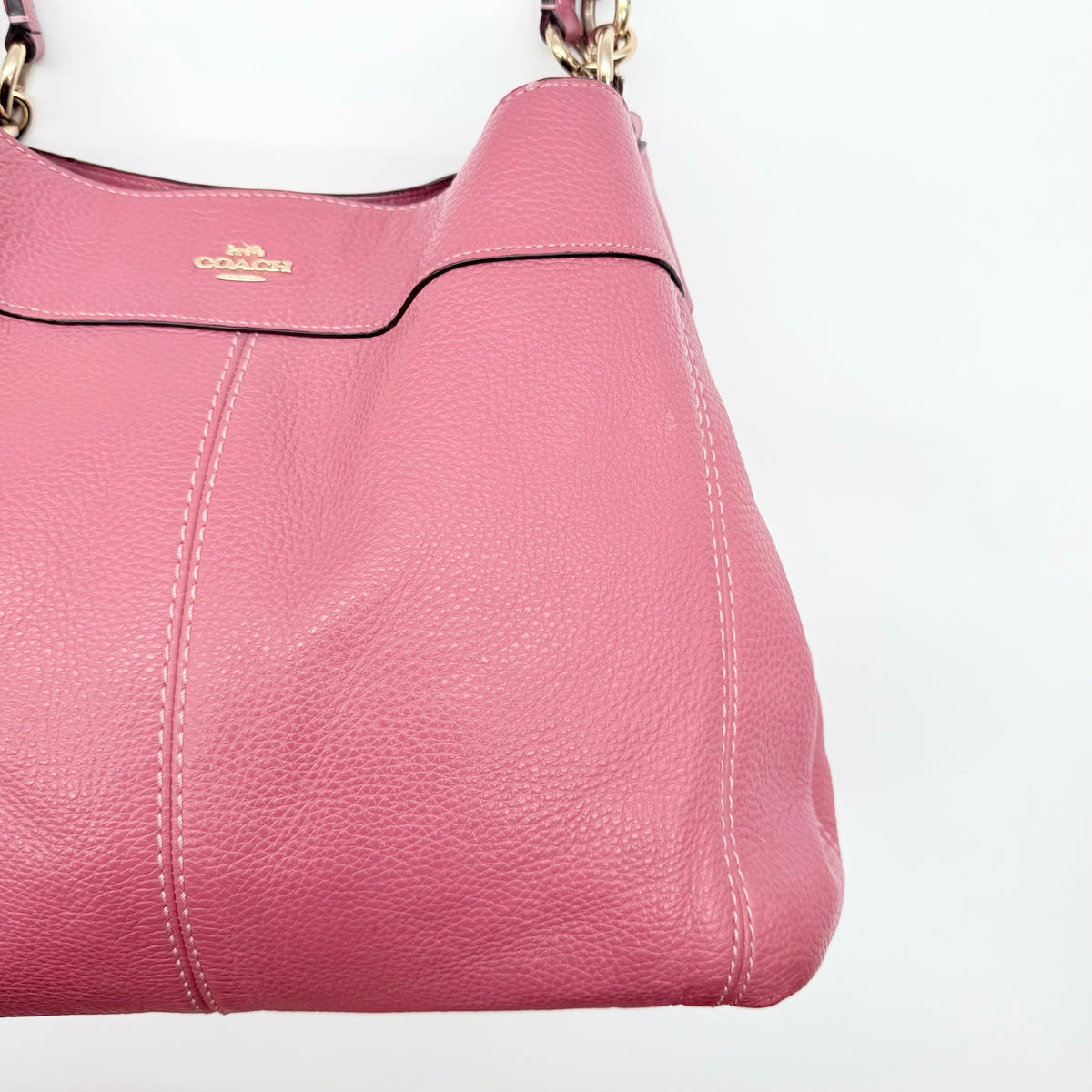 Coach Lexy Shoulder Bag in pink pebbled leather with gold hardware and dual straps, shown against a white background.