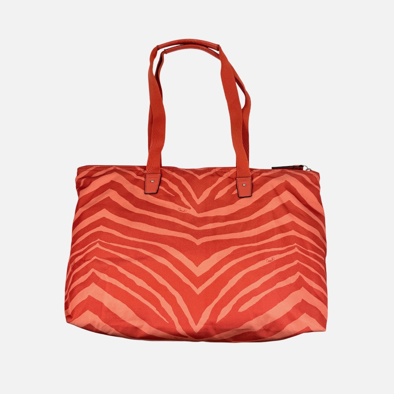 Coach Getaway Weekender tote and matching pouch in orange zebra print, with structured silhouette and bold colour.