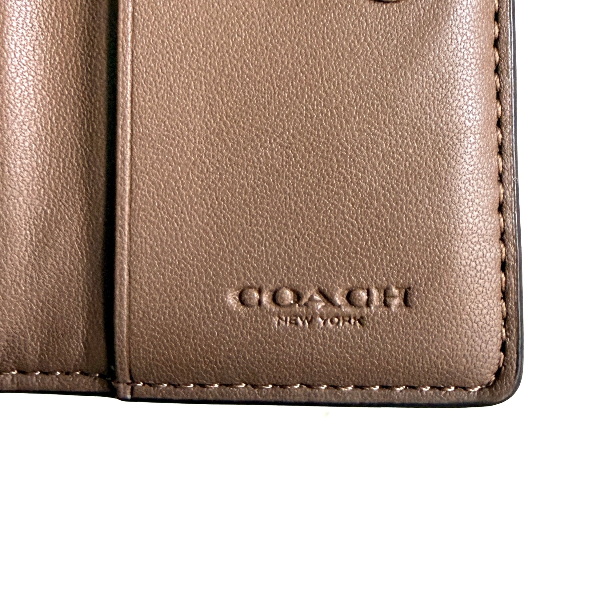 Coach Signature Canvas Key Case in beige with gold-tone logo and signature monogram pattern, shown in a front view.