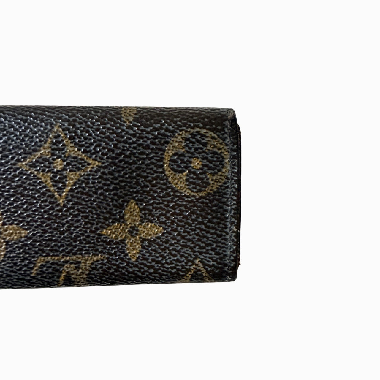 Louis Vuitton monogram key case in brown with gold-tone snap closure and classic LV pattern on coated canvas.