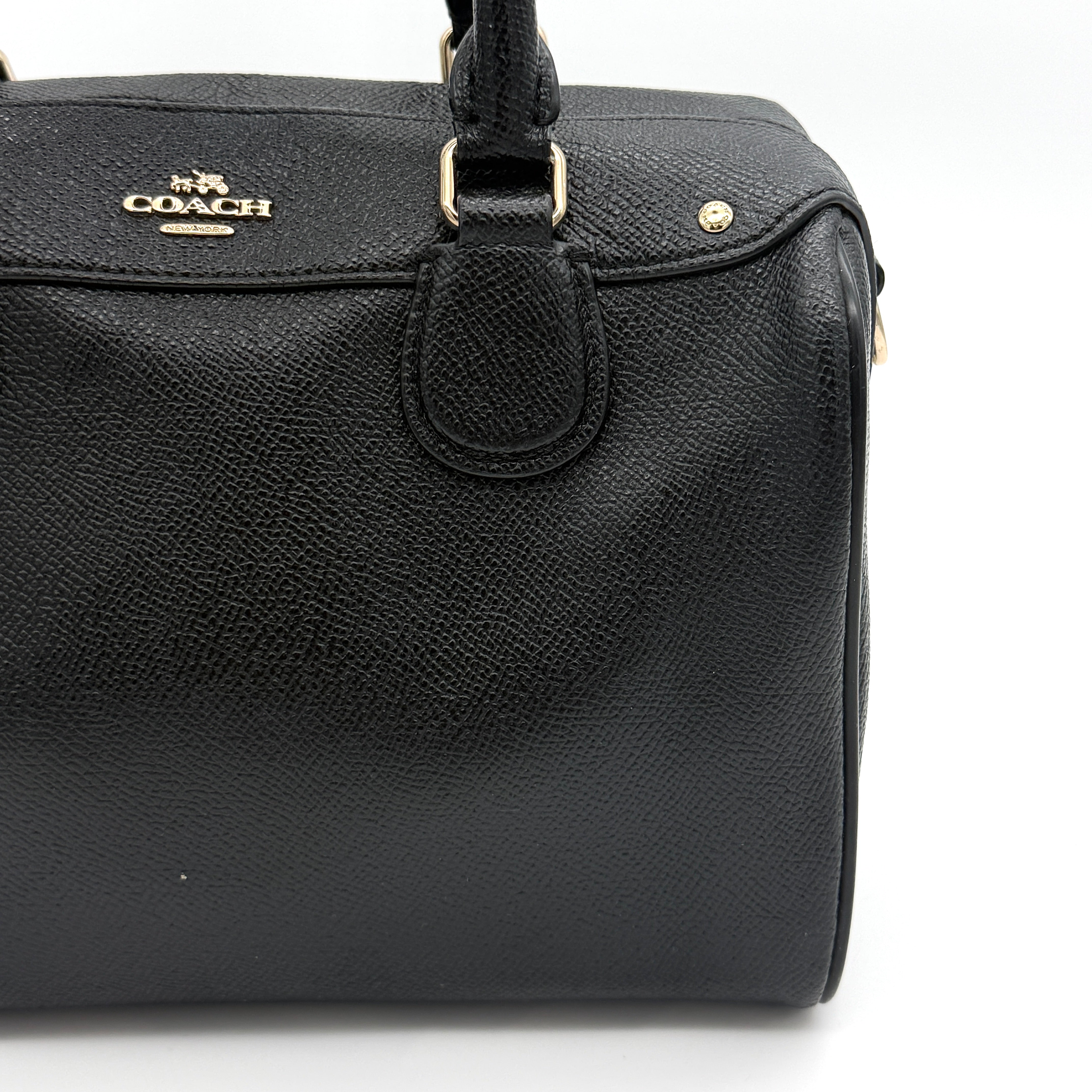 Front-facing image of the Coach Mini Bennett Boston Bag in black grained leather with gold hardware.