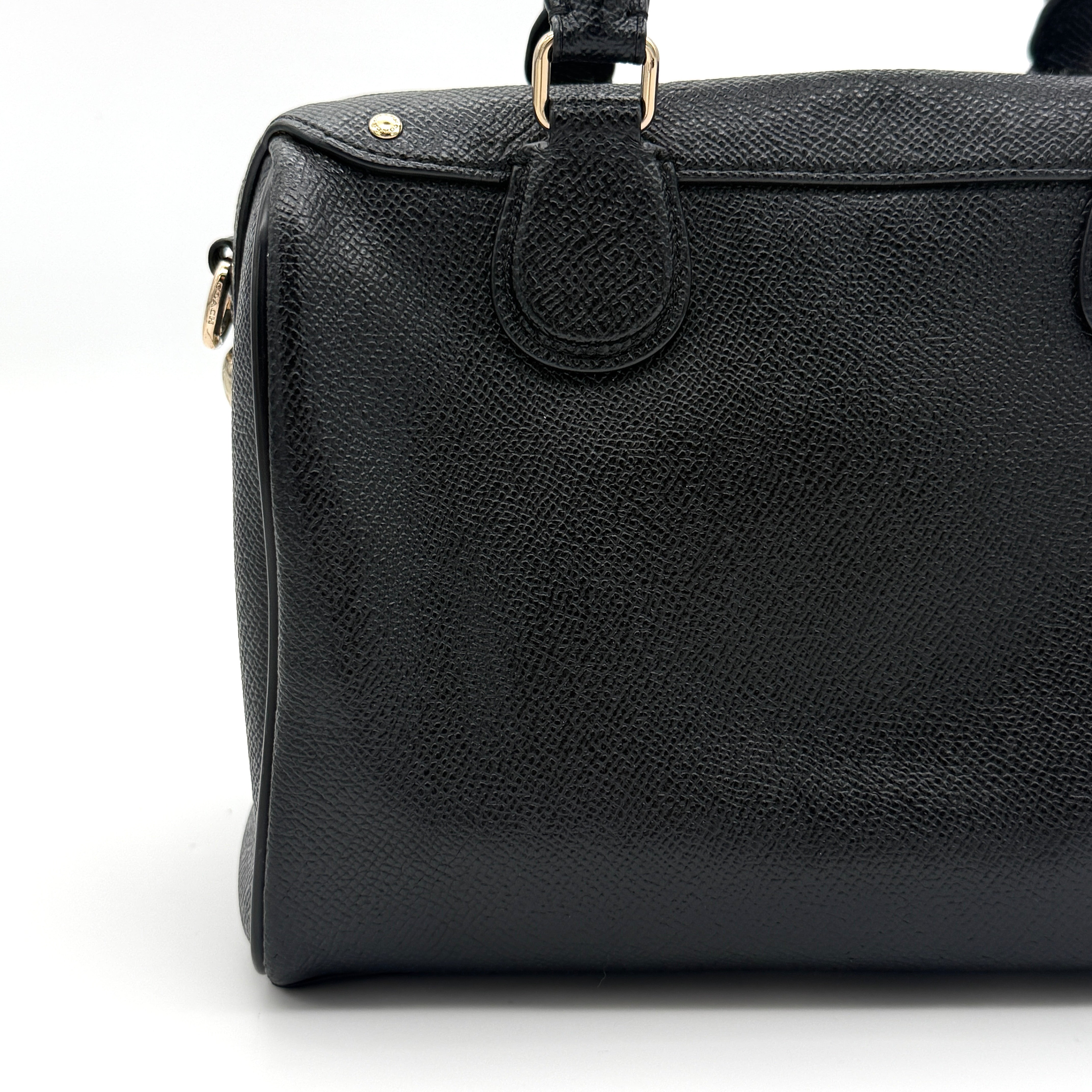 Front-facing image of the Coach Mini Bennett Boston Bag in black grained leather with gold hardware.