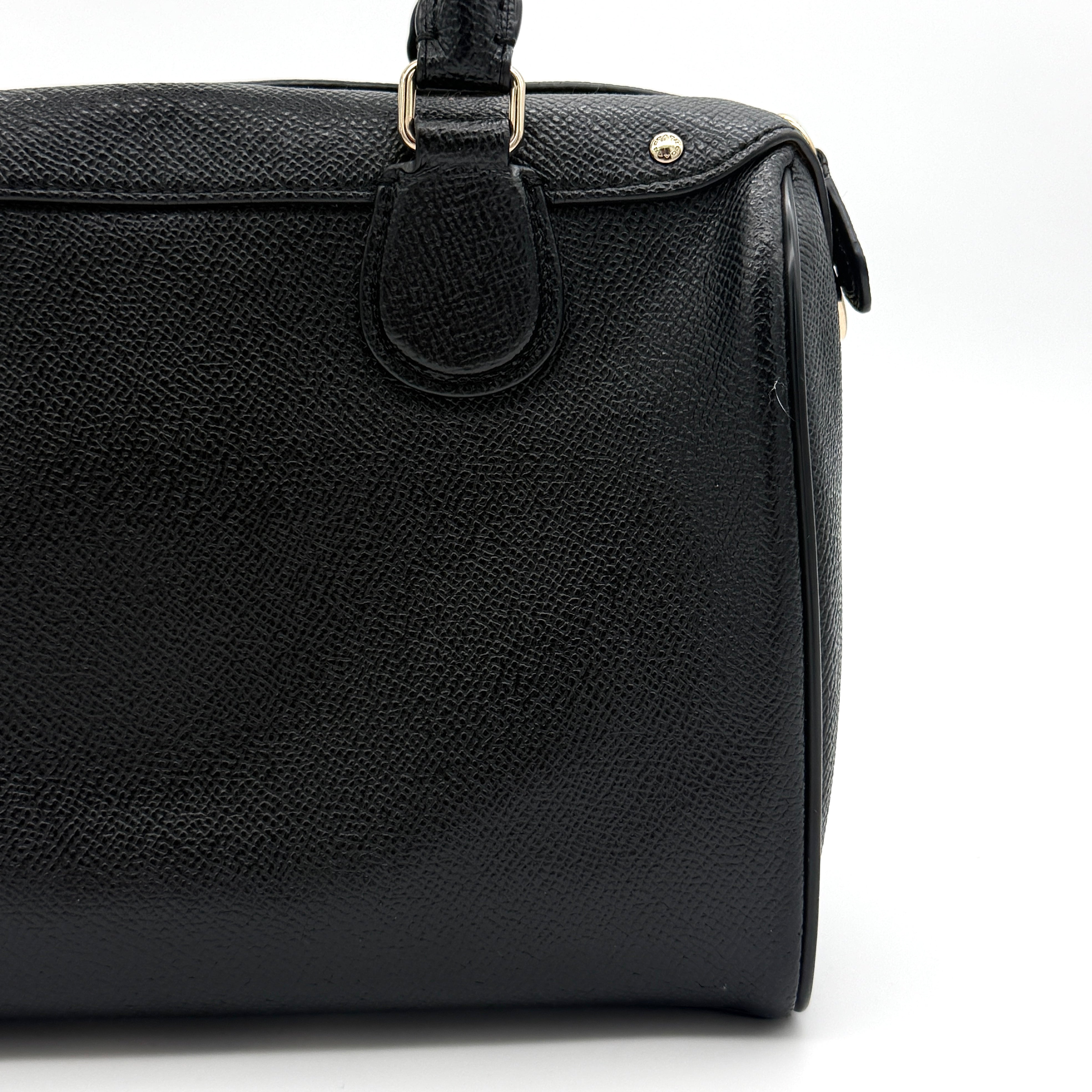 Front-facing image of the Coach Mini Bennett Boston Bag in black grained leather with gold hardware.