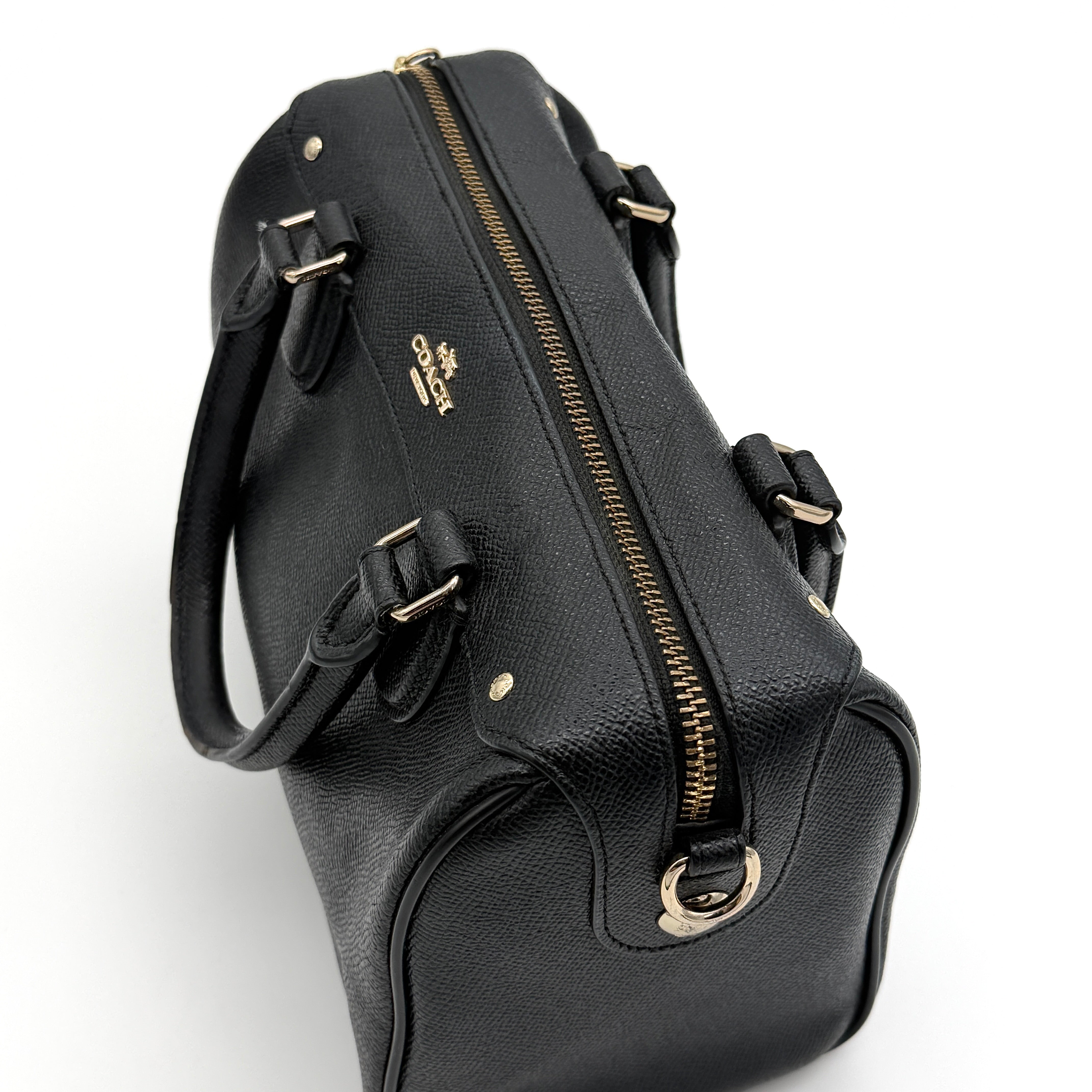 Front-facing image of the Coach Mini Bennett Boston Bag in black grained leather with gold hardware.