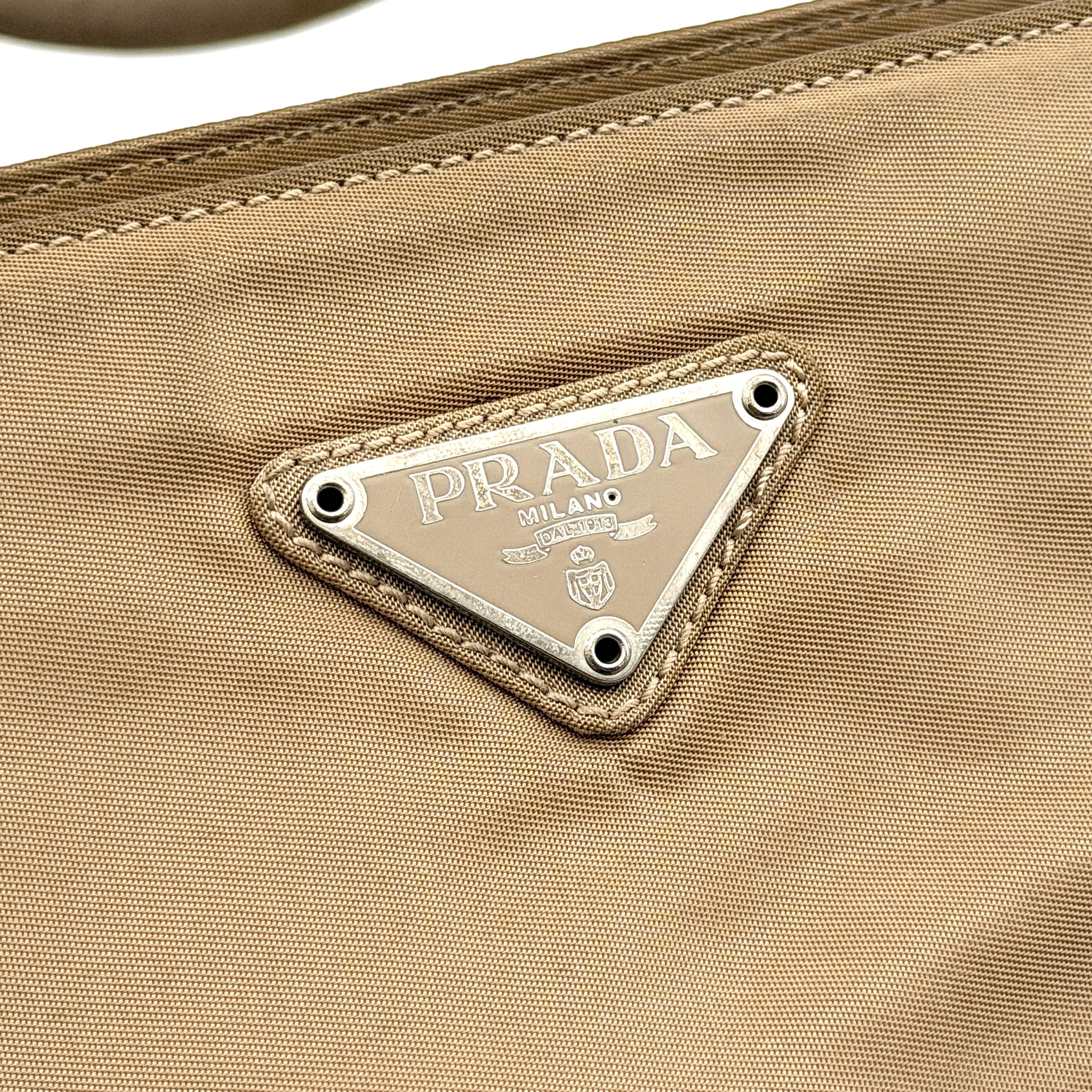 Prada Tessuto nylon tote bag in beige with silver-tone logo plaque and dual handles.