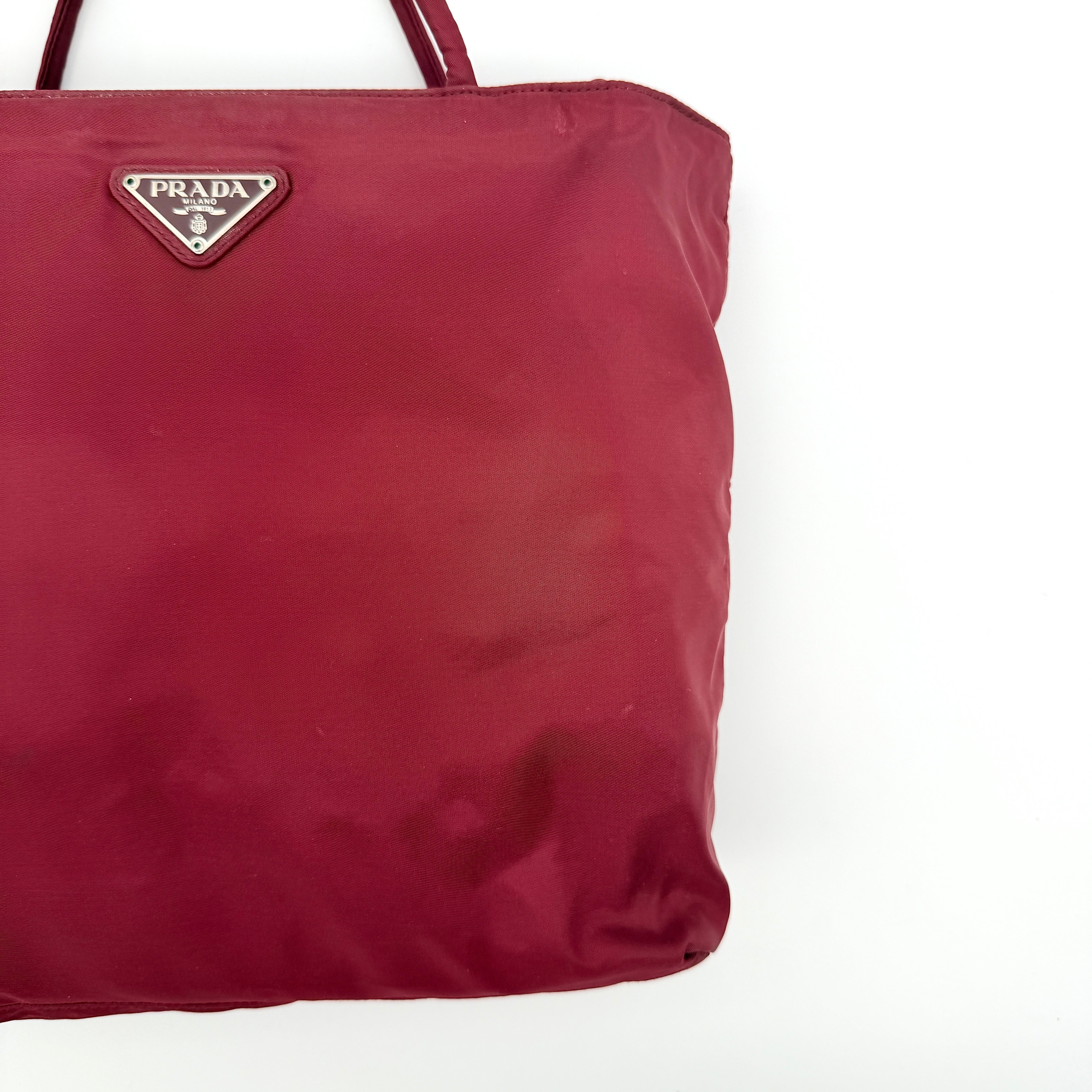 Red Prada Tessuto Nylon Tote Bag with double shoulder straps and classic enamel logo, displayed against a white background.