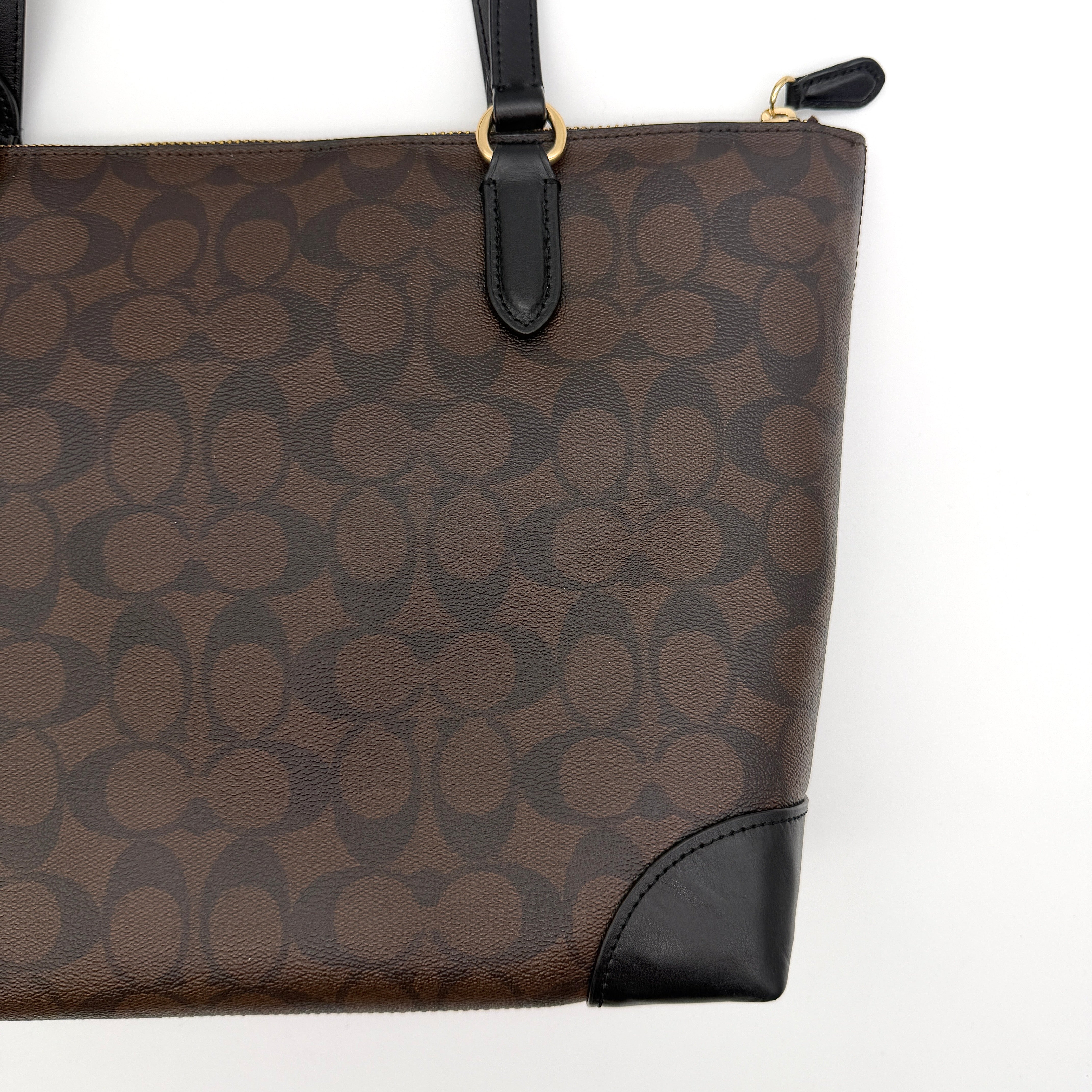 Coach Signature Zip Top Tote Bag in brown and black canvas with leather trim and gold-tone hardware.