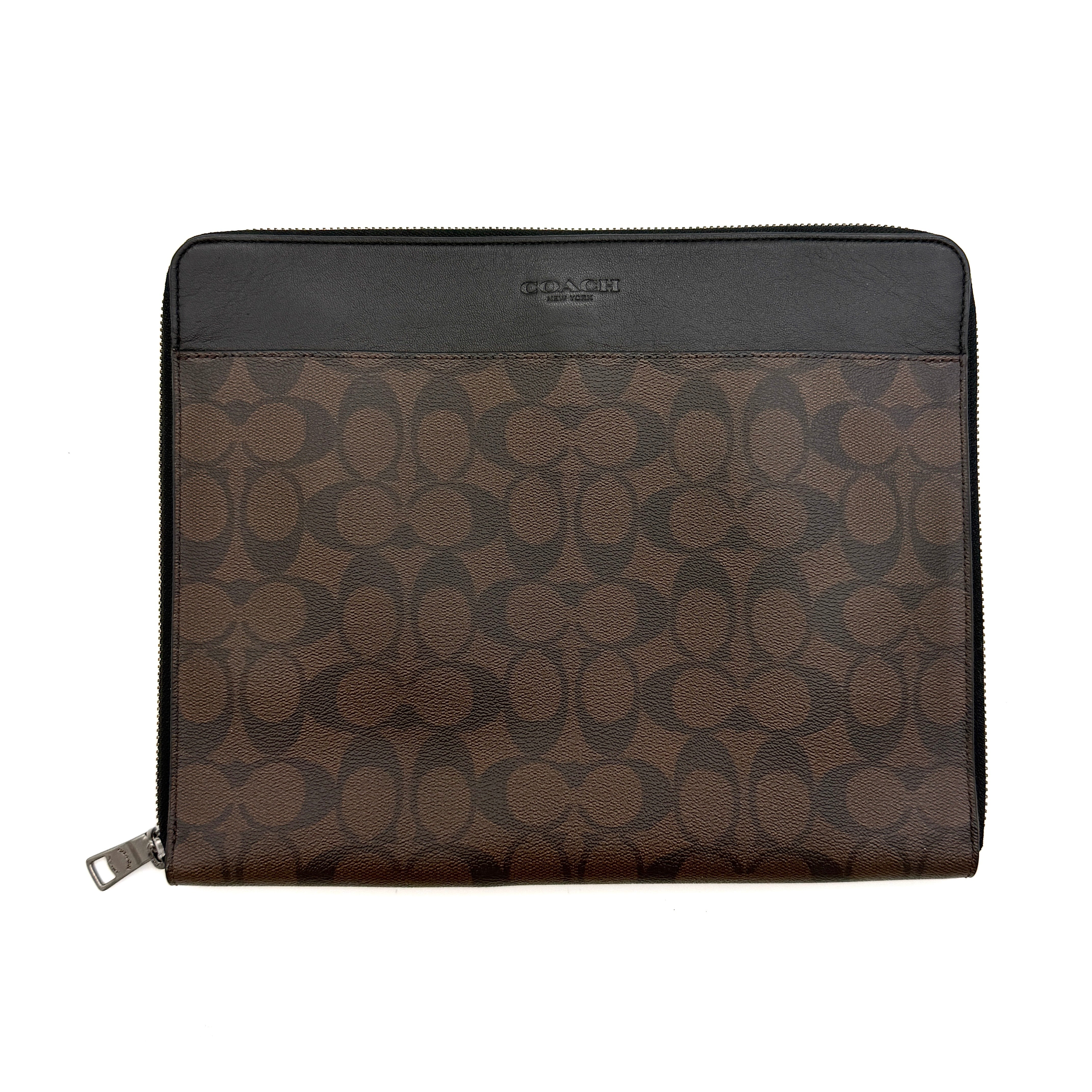 Coach Signature Zip Portfolio in brown and black monogram canvas with zip-around closure, displayed flat against a white background.
