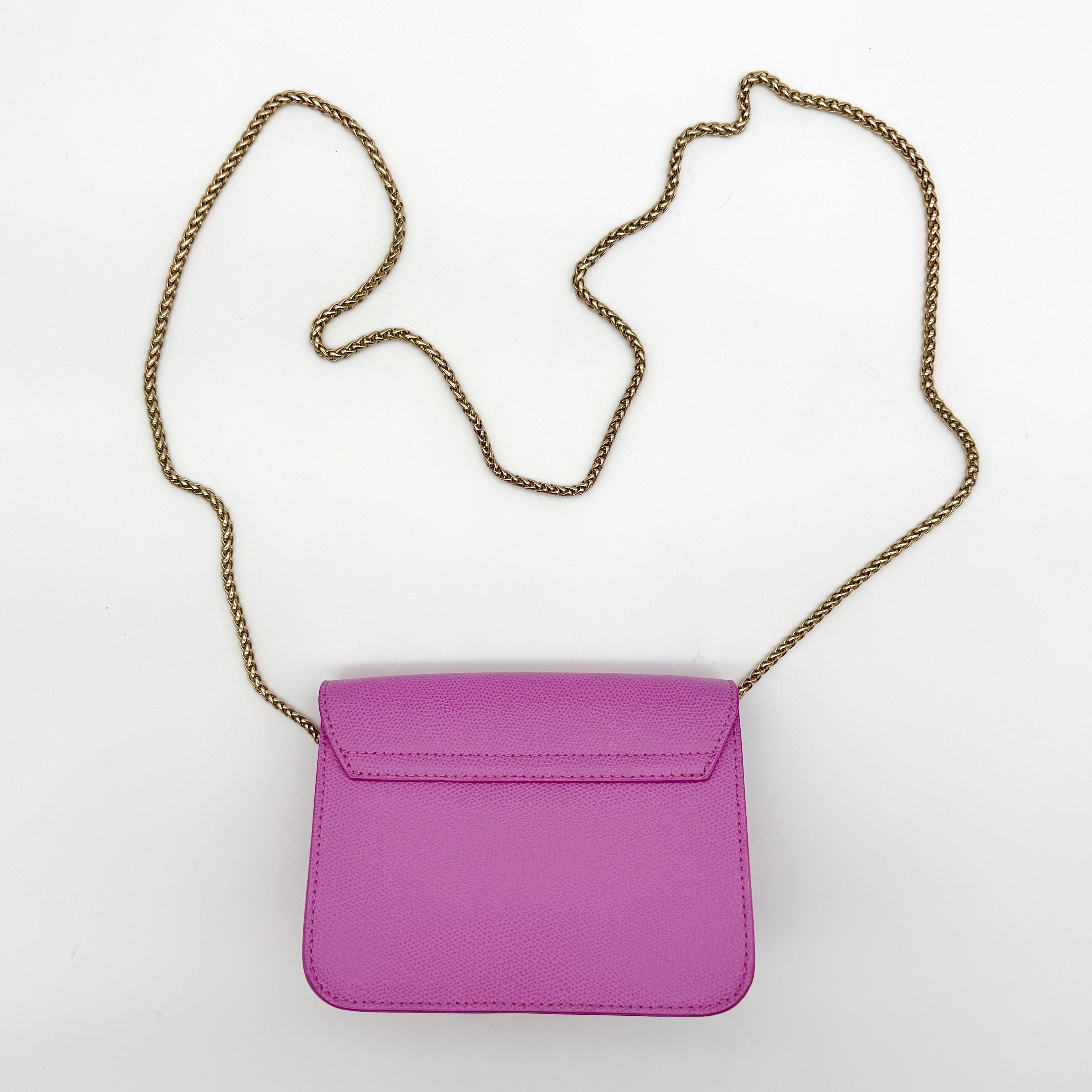 Furla Metropolis crossbody bag in pink grained leather with gold hardware and chain strap, displayed against a white background.