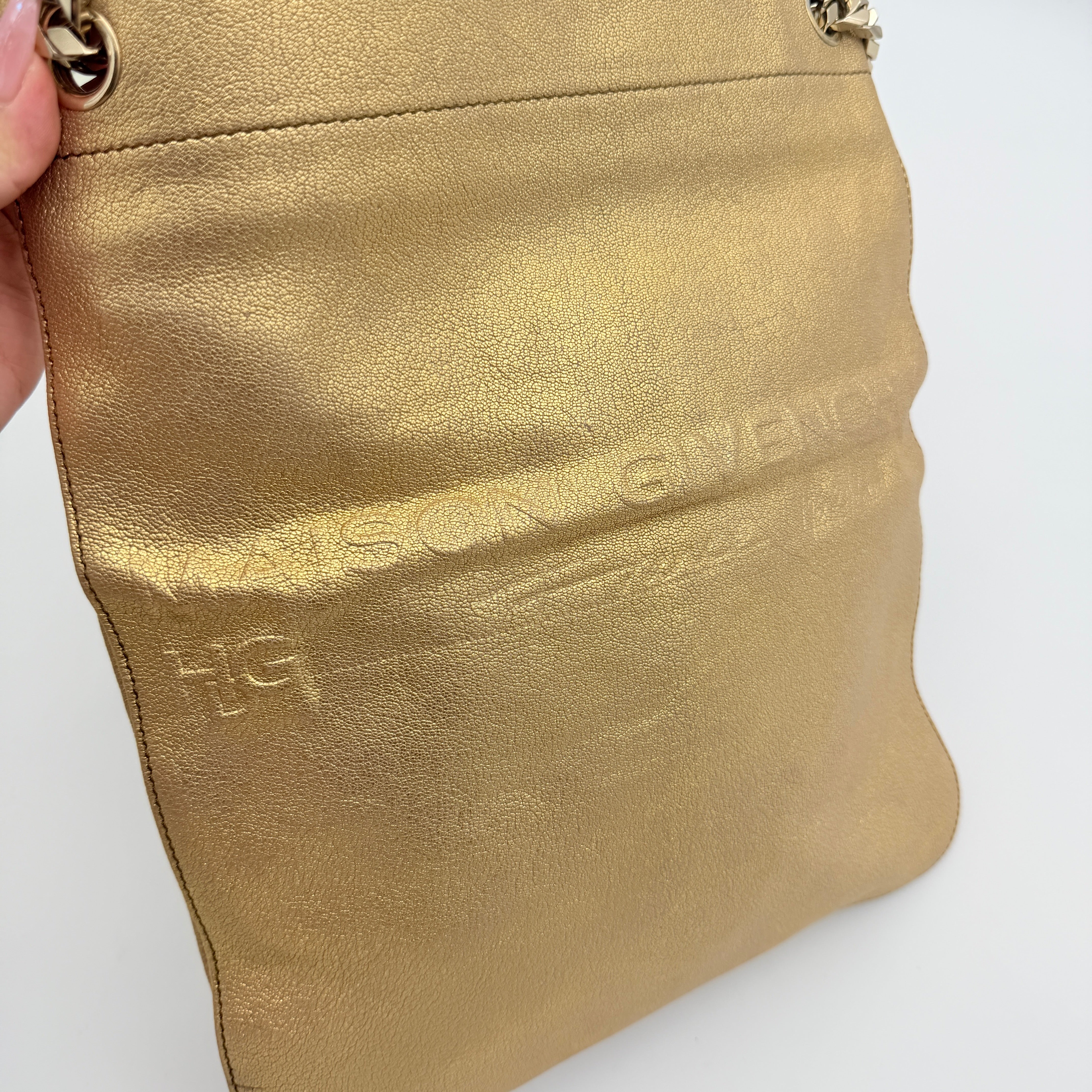 Givenchy metallic gold chain shoulder bag with gold-tone chain straps and embossed logo, displayed on a dust bag.