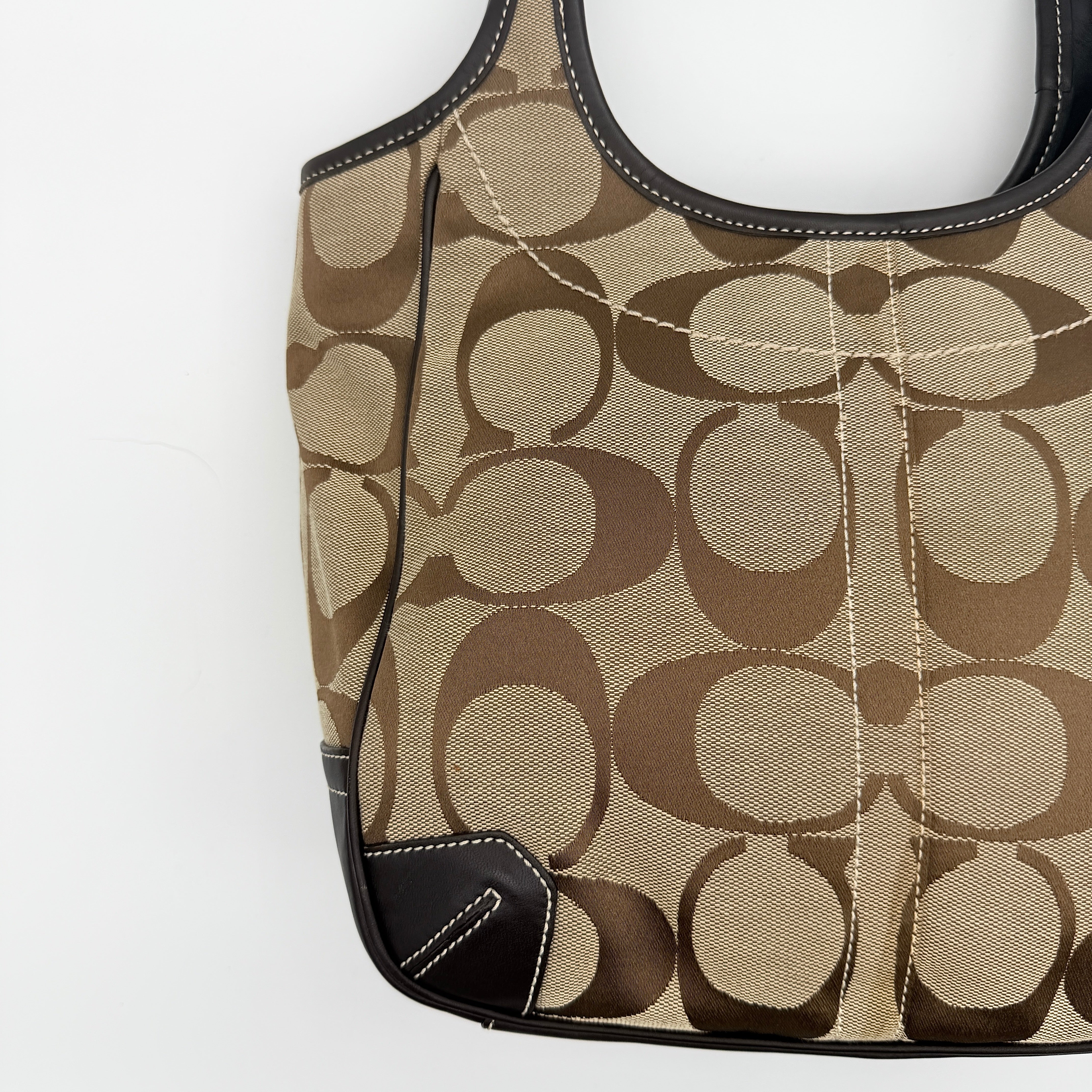 Coach Signature Ergo Hobo Tote Bag in beige and brown canvas with front pocket and dark leather trim, shown on a white background.