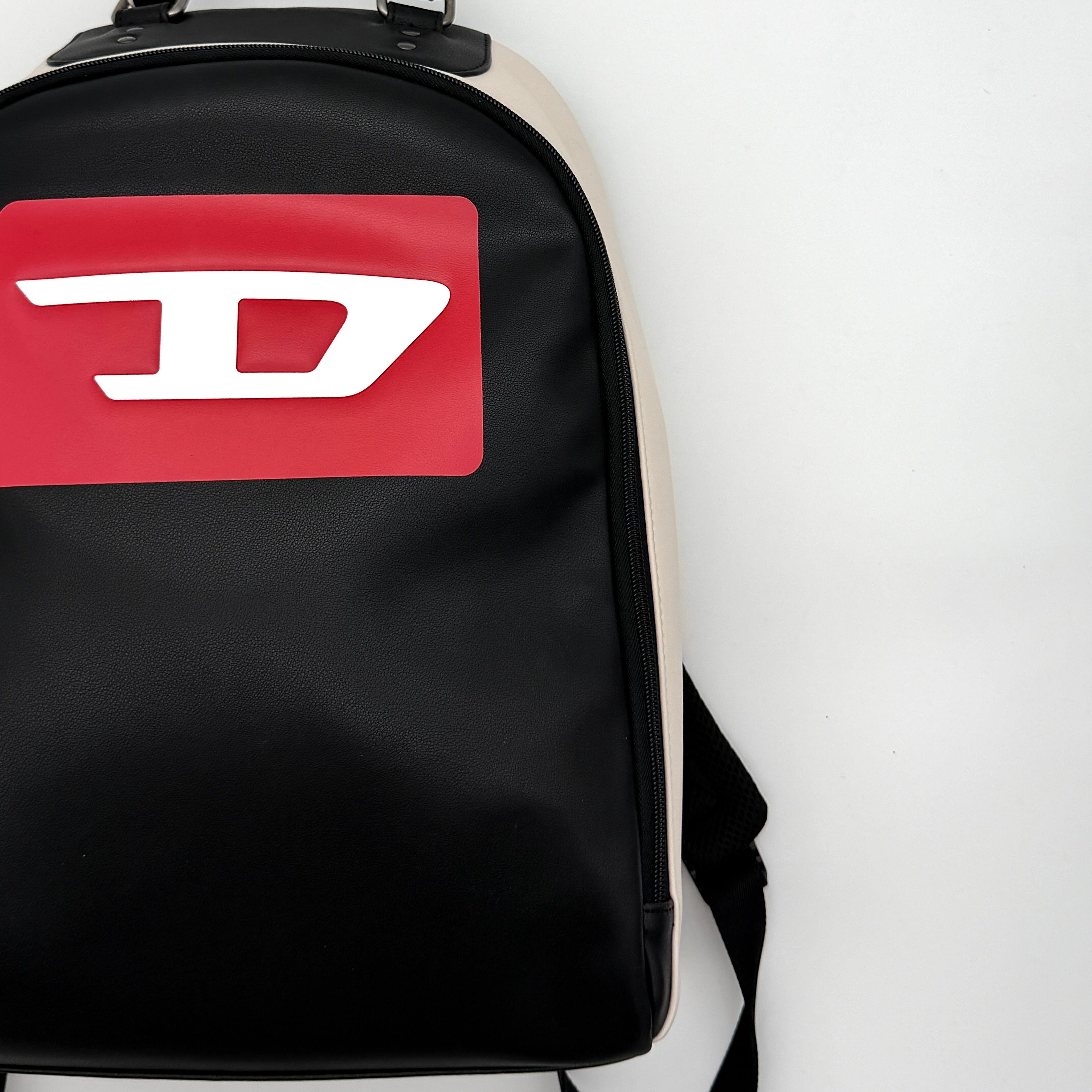 Diesel D-Logo Colorblock Backpack in black and white faux leather with a red logo patch and silver-tone hardware.