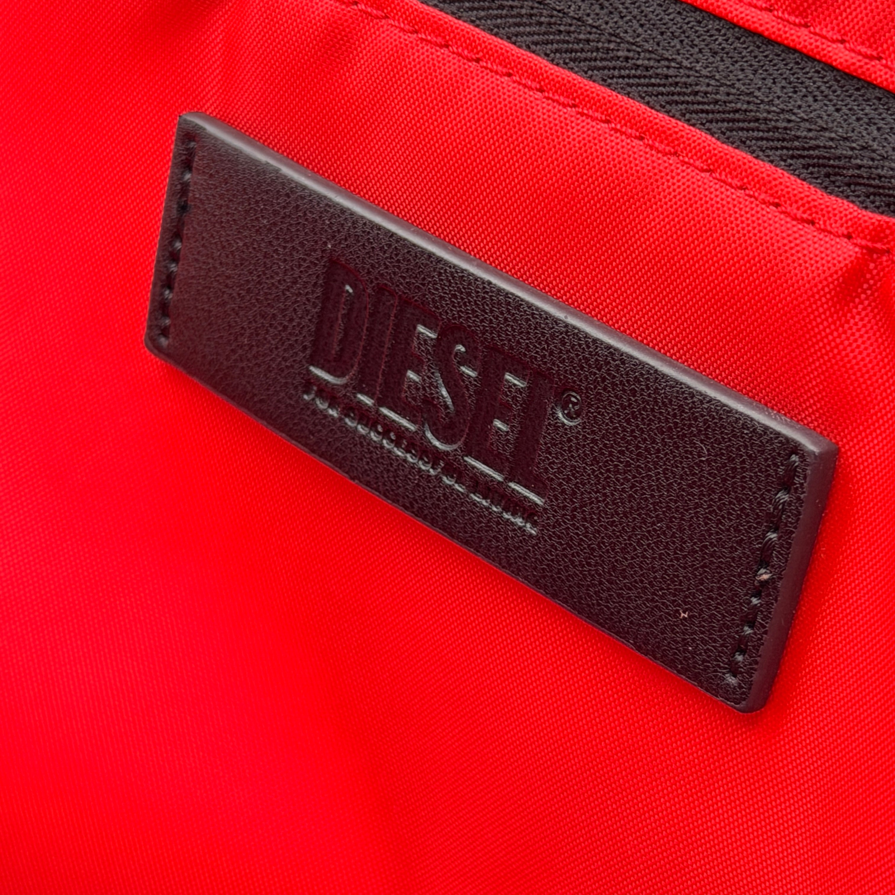 Diesel D-Logo Colorblock Backpack in black and white faux leather with a red logo patch and silver-tone hardware.