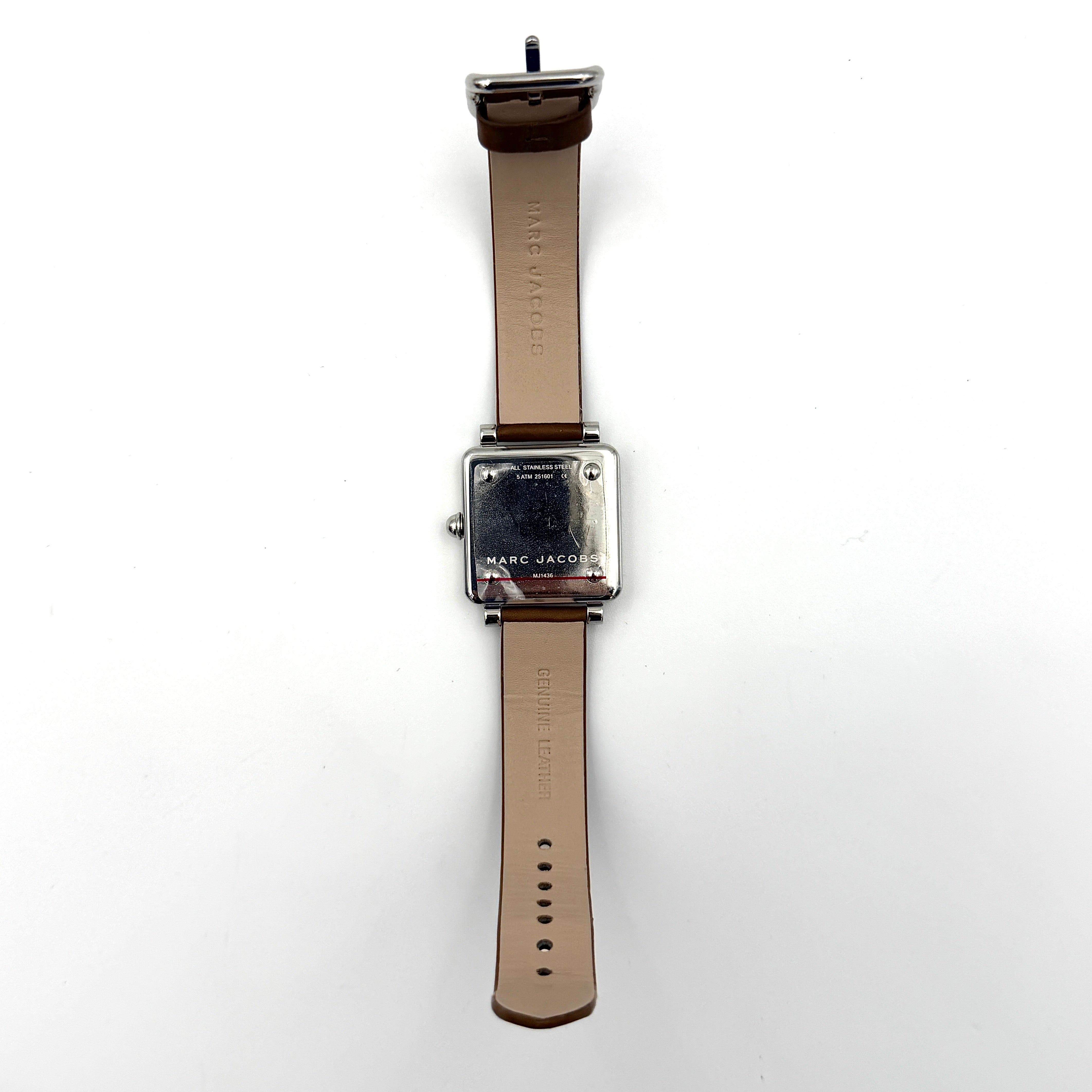 Marc Jacobs MJ1436 silver square watch with brown leather strap displayed on a branded watch cushion.