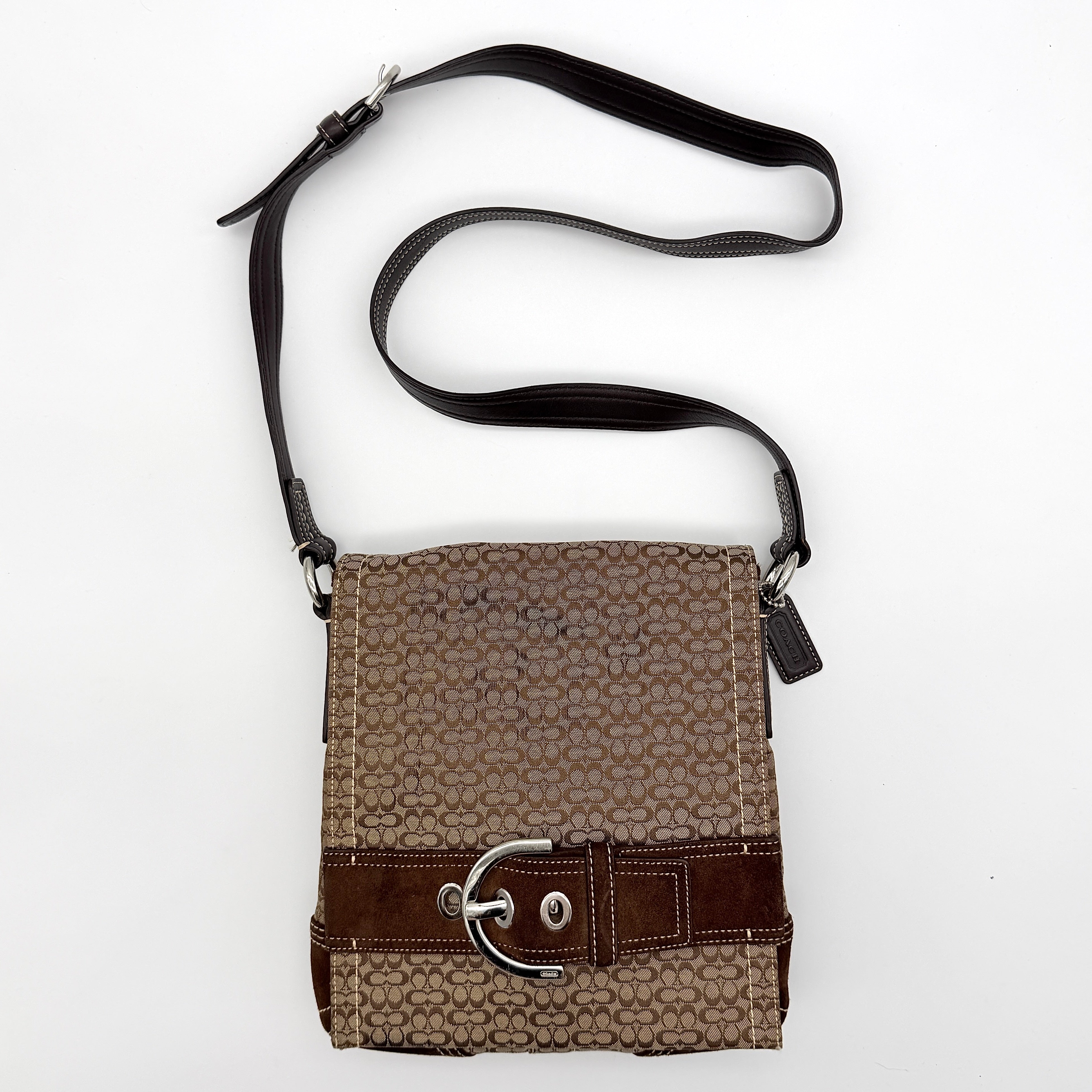 Coach Signature Soho Flap Crossbody Bag in brown jacquard canvas with suede trim and silver buckle, shown with adjustable strap.