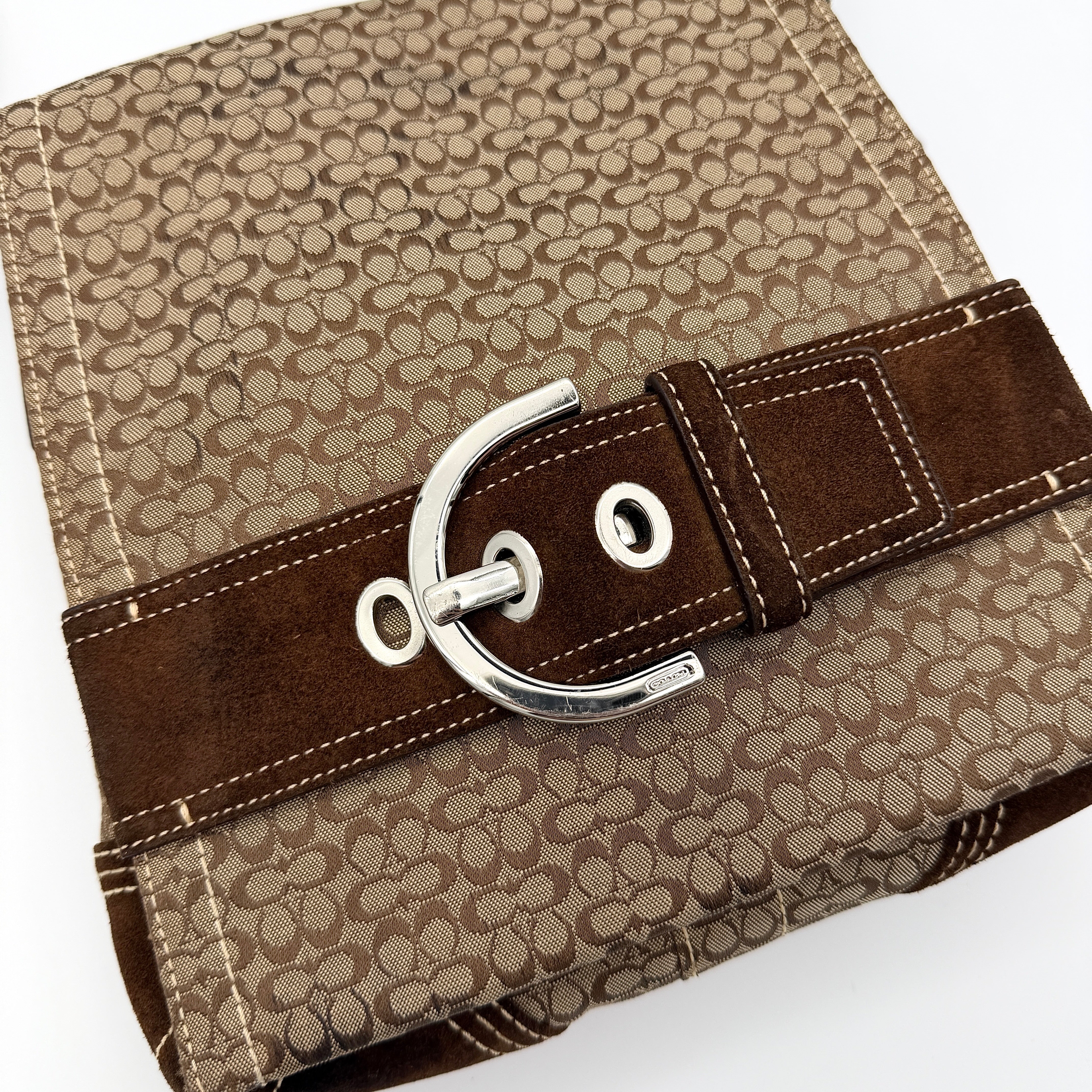 Coach Signature Soho Flap Crossbody Bag in brown jacquard canvas with suede trim and silver buckle, shown with adjustable strap.