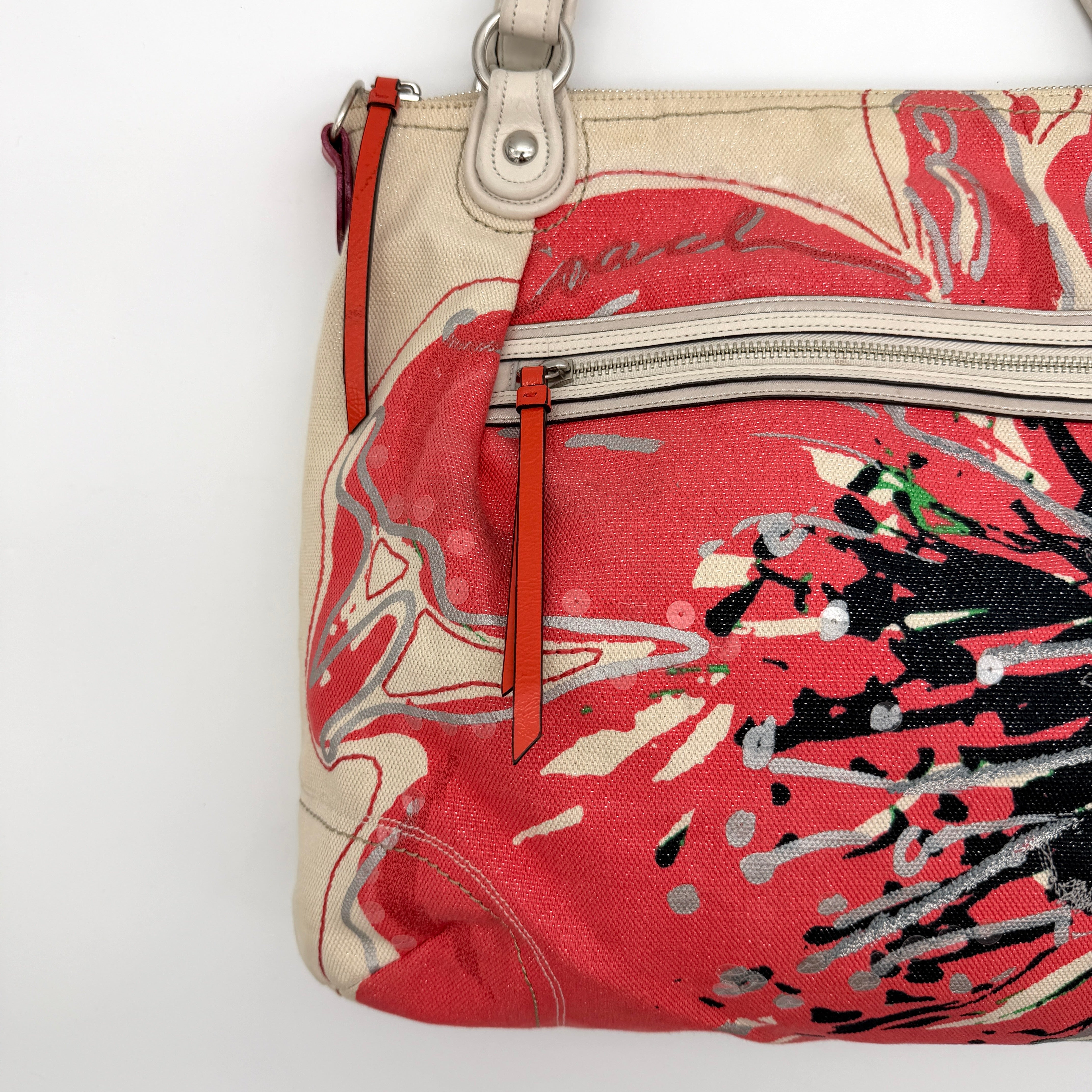 Coach Poppy Glam Floral Shoulder Bag in canvas with a bold multicolour floral print and cream leather handles, photographed on white.