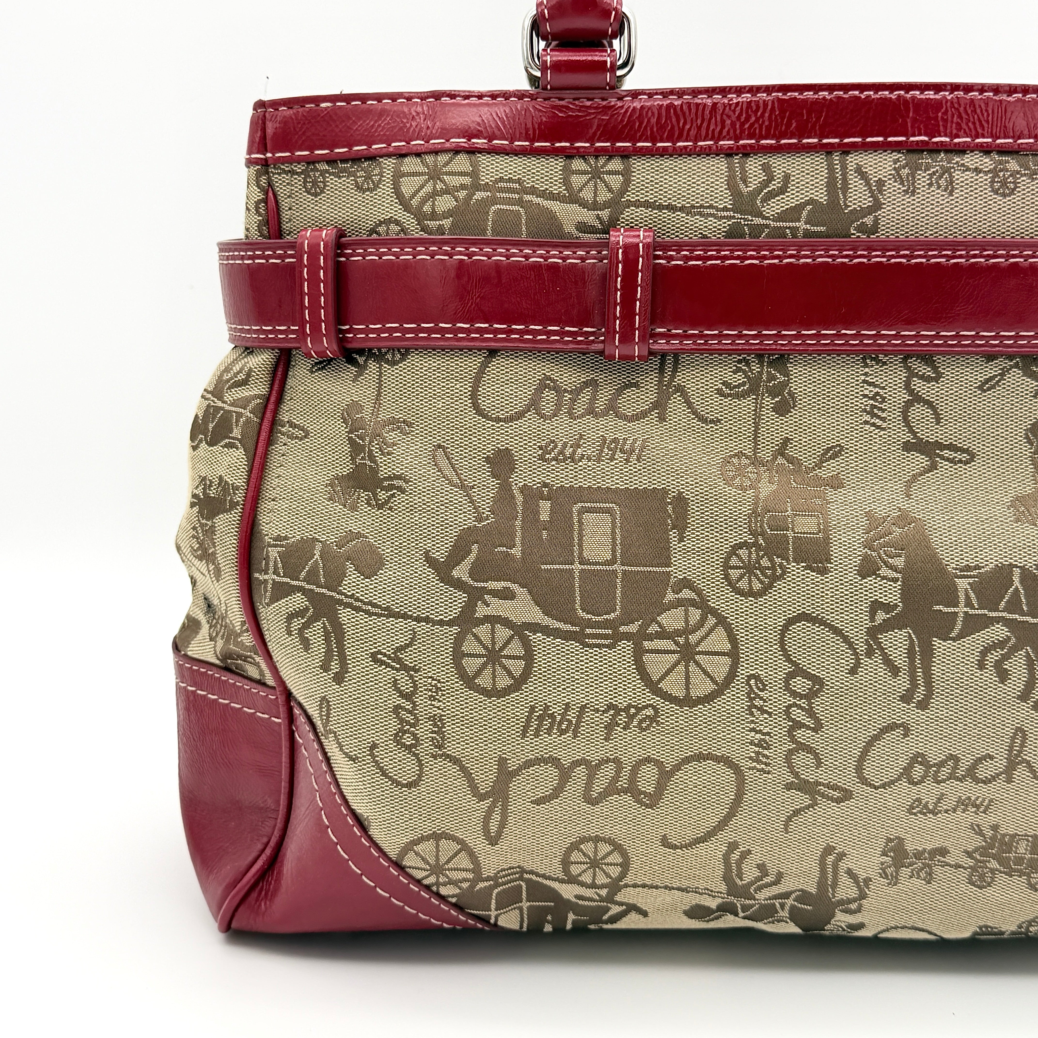 Coach Hampton Carryall in beige canvas with horse carriage motif, red leather trim, and double handles.