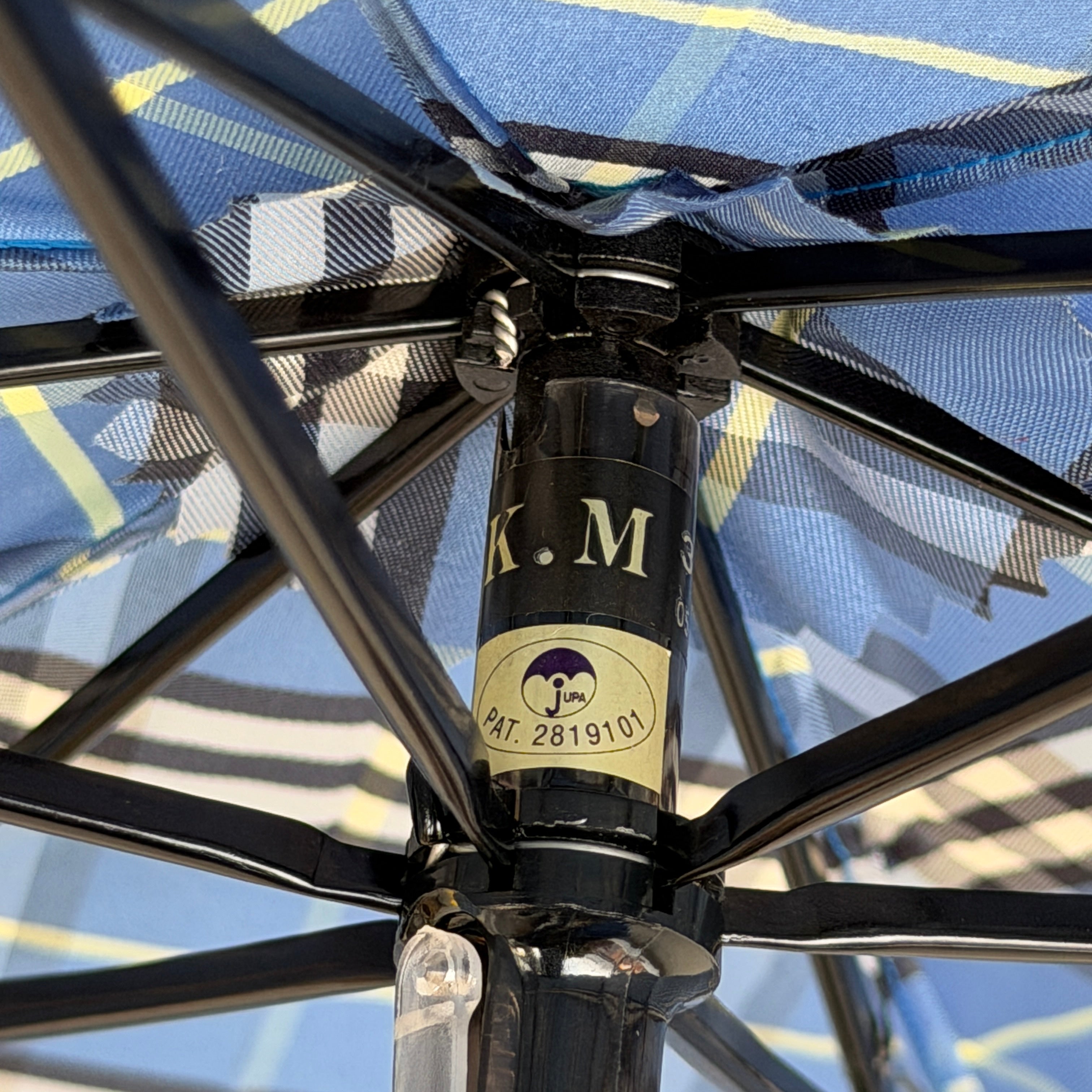 Burberry folding umbrella and matching pouch in blue Nova Check plaid, perfectly folded to showcase its classic pattern and refined finish.