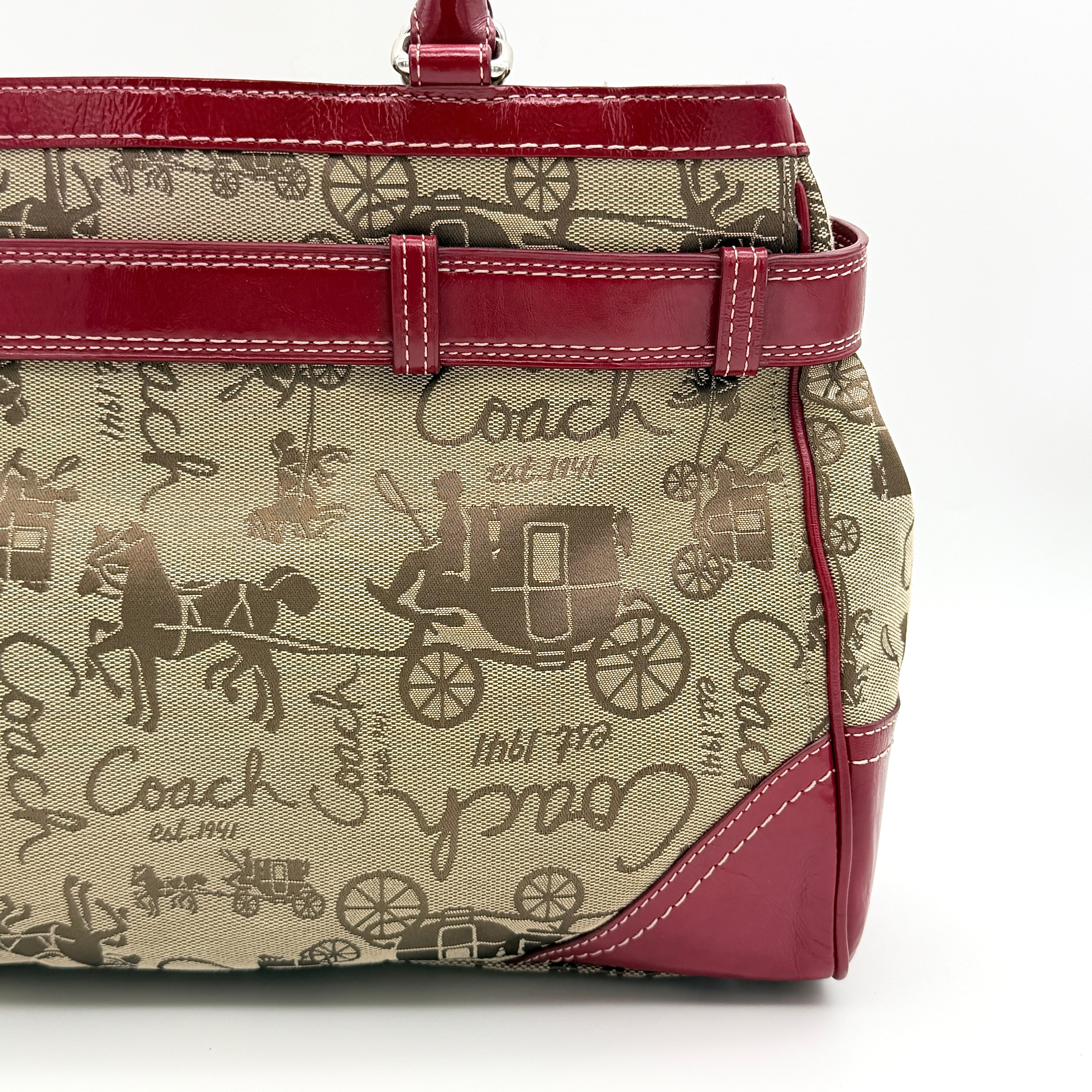 Coach Hampton Carryall in beige canvas with horse carriage motif, red leather trim, and double handles.