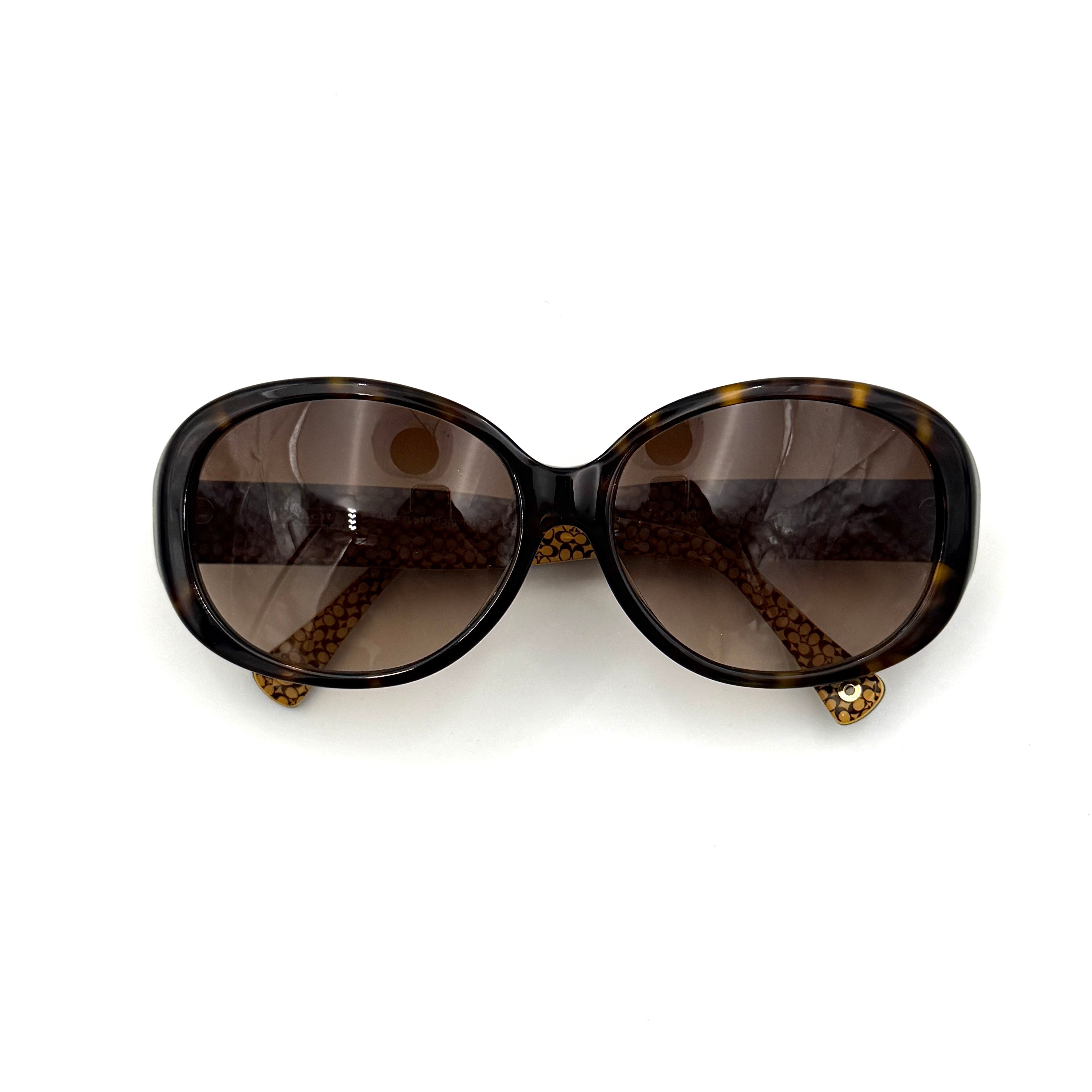 Coach HC8038F sunglasses in dark tortoise acetate with oversized oval frames and gold logo detail on the temple.