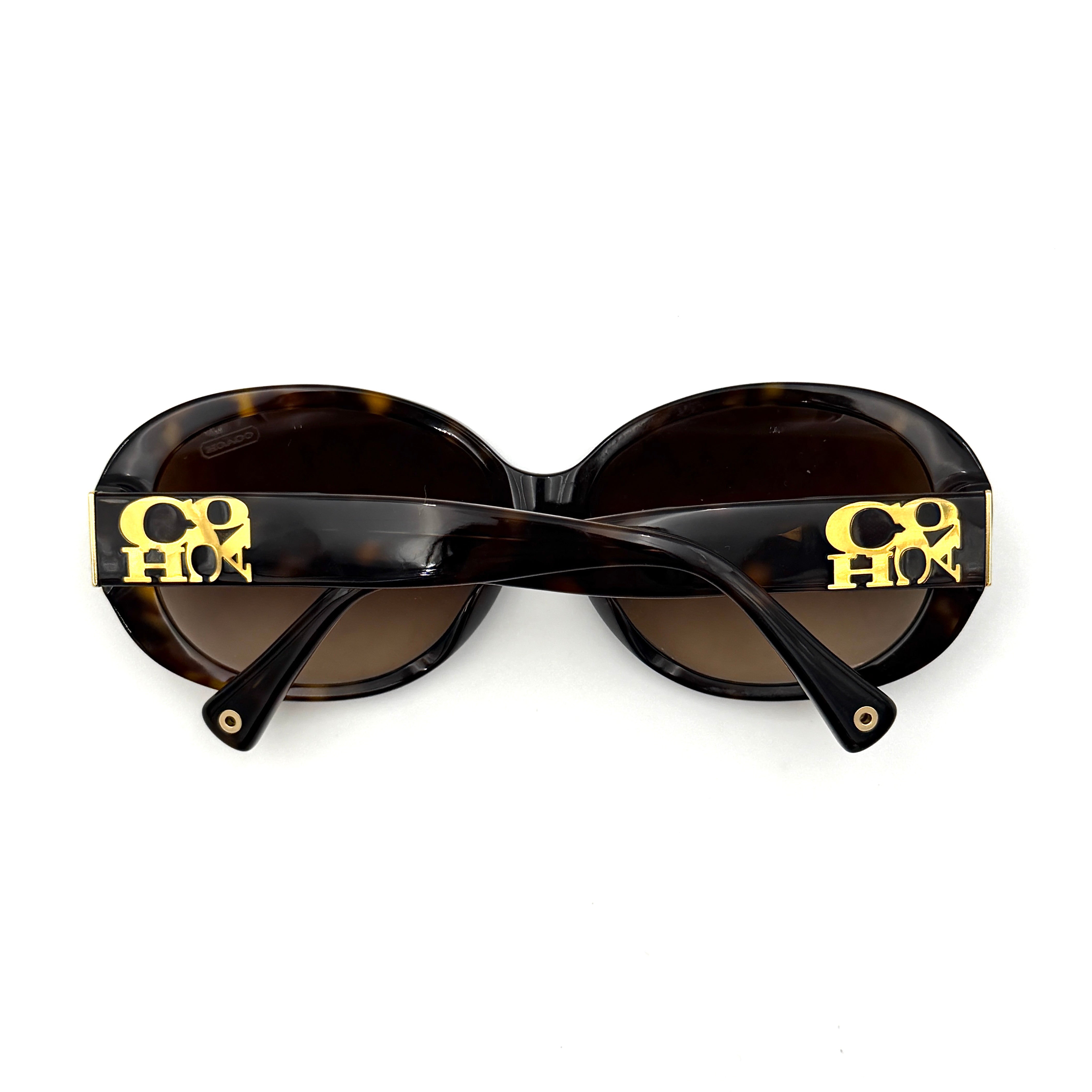 Coach HC8038F sunglasses in dark tortoise acetate with oversized oval frames and gold logo detail on the temple.