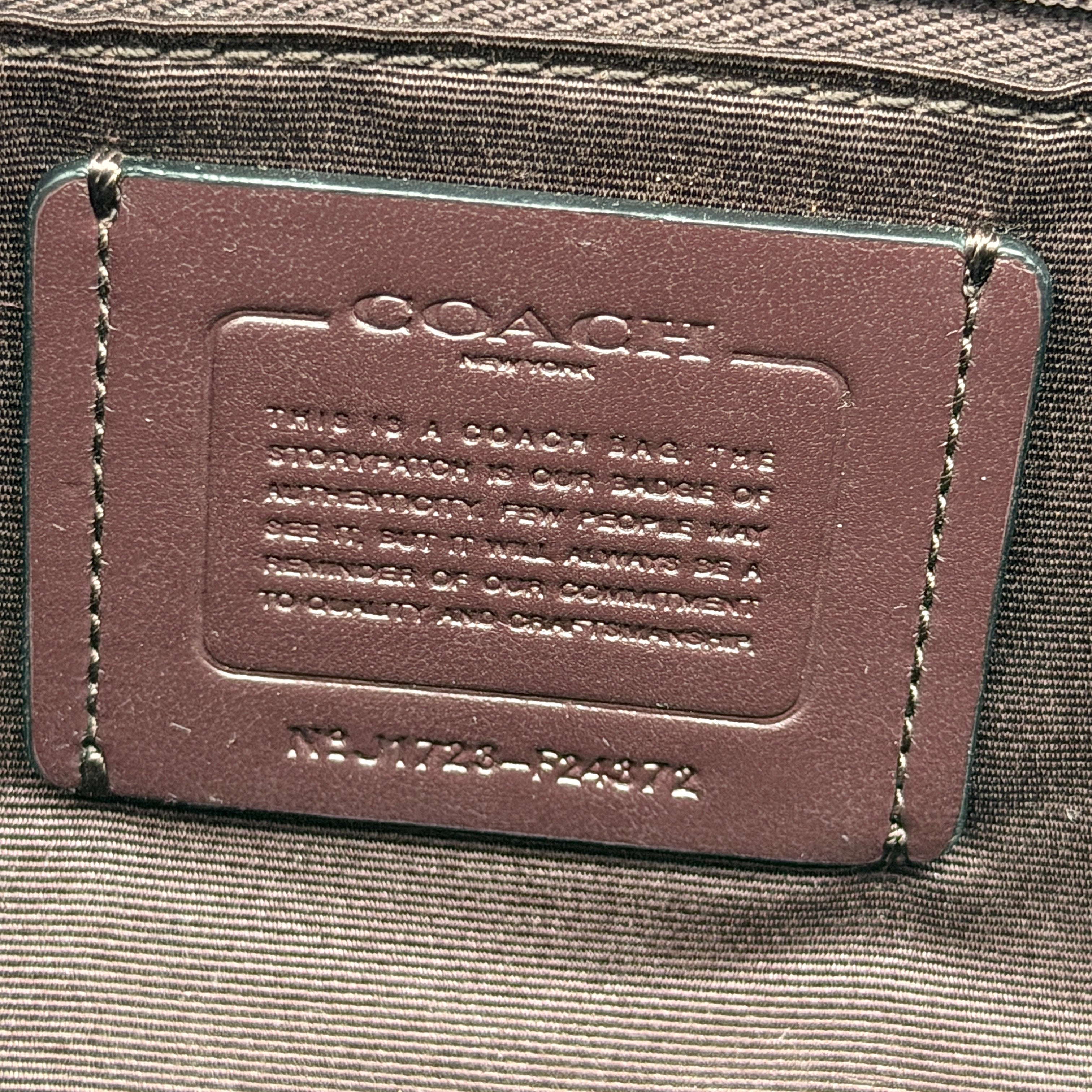 Coach brown coated canvas city tote with pink and lavender floral print, burgundy handles, and gold-tone logo at the front.