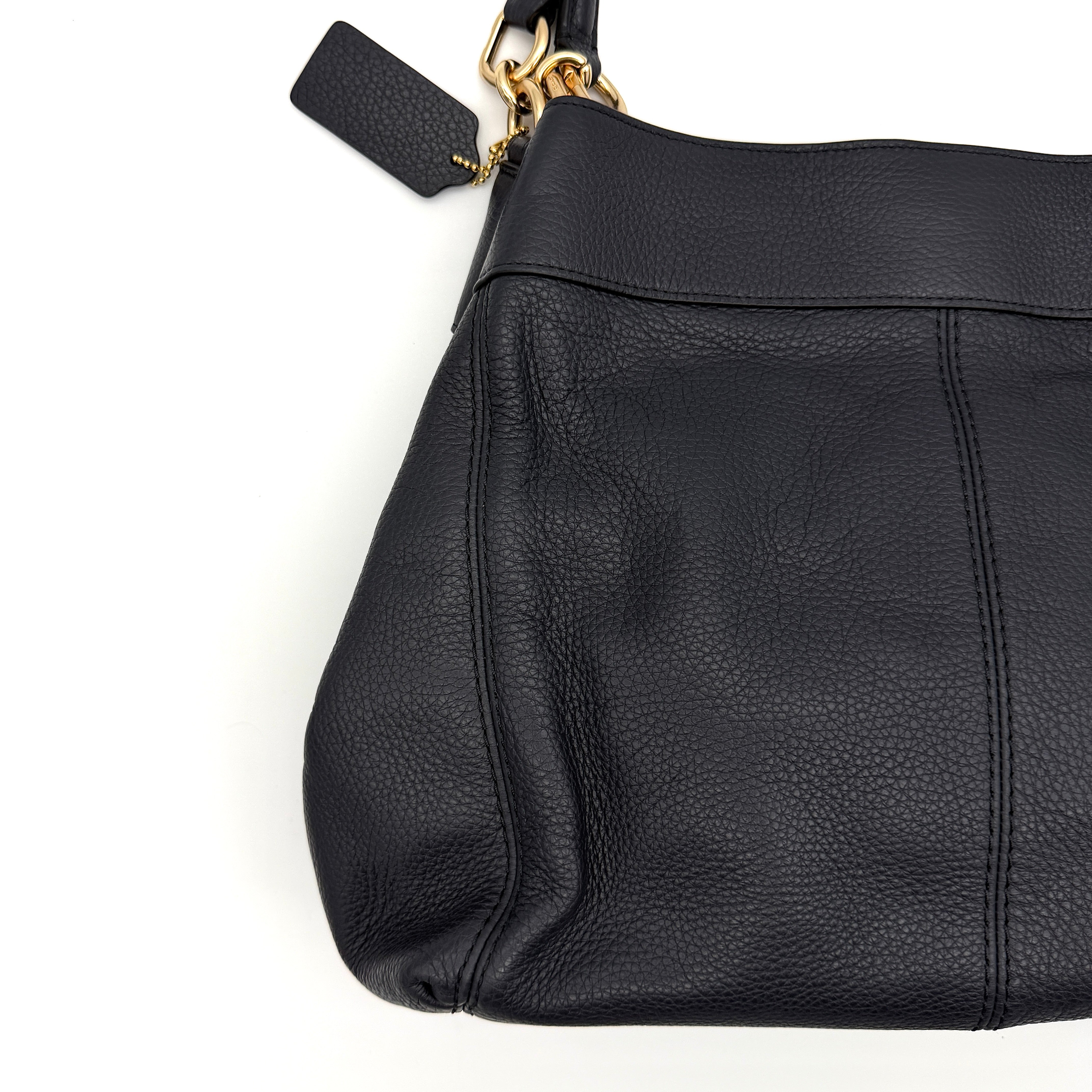 Coach Lexy shoulder bag in navy pebbled leather with gold-tone hardware and double handles.