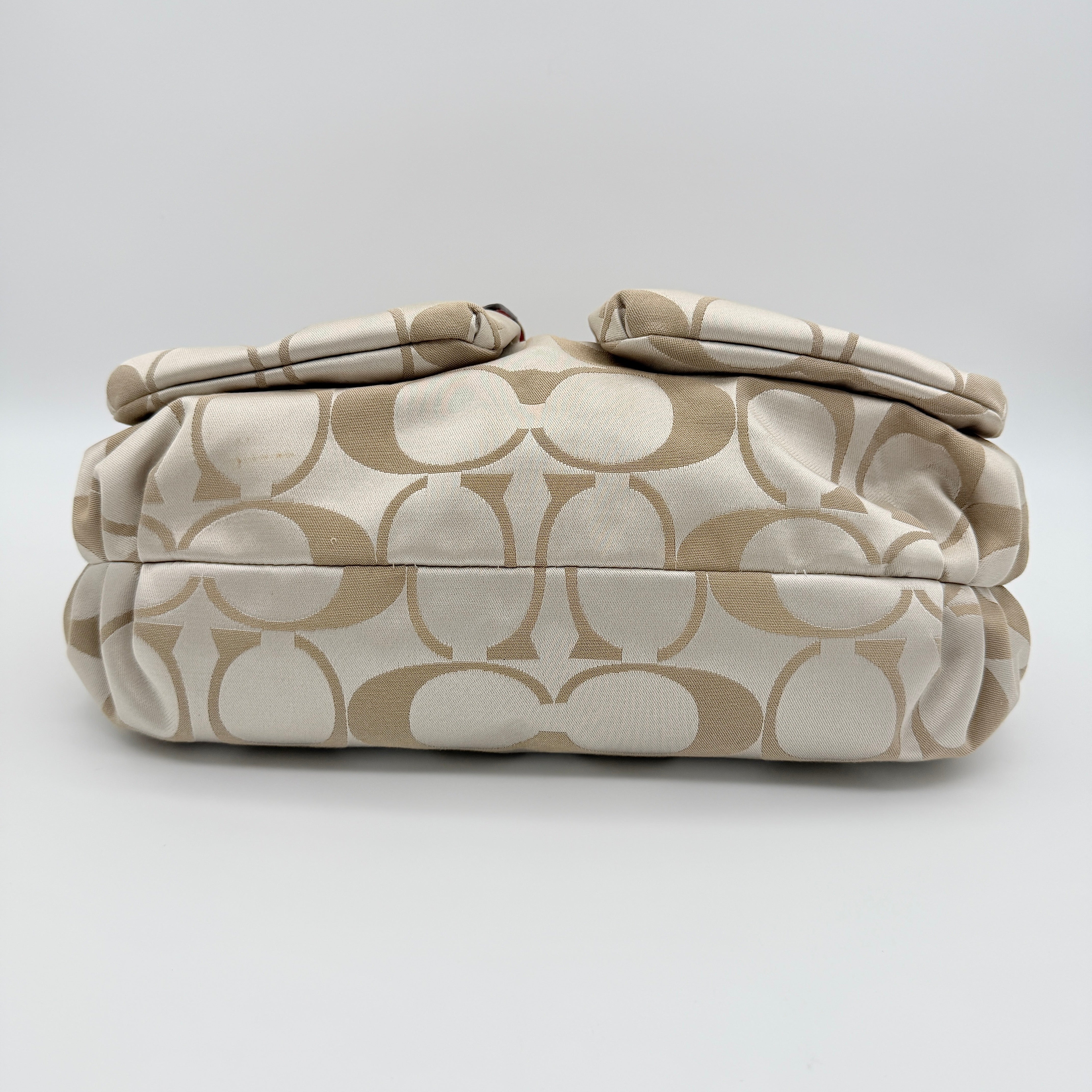 Coach Signature Poppy Pocket Hobo in beige sateen canvas with pink leather trim and silver hardware, front view with double pockets and charms.
