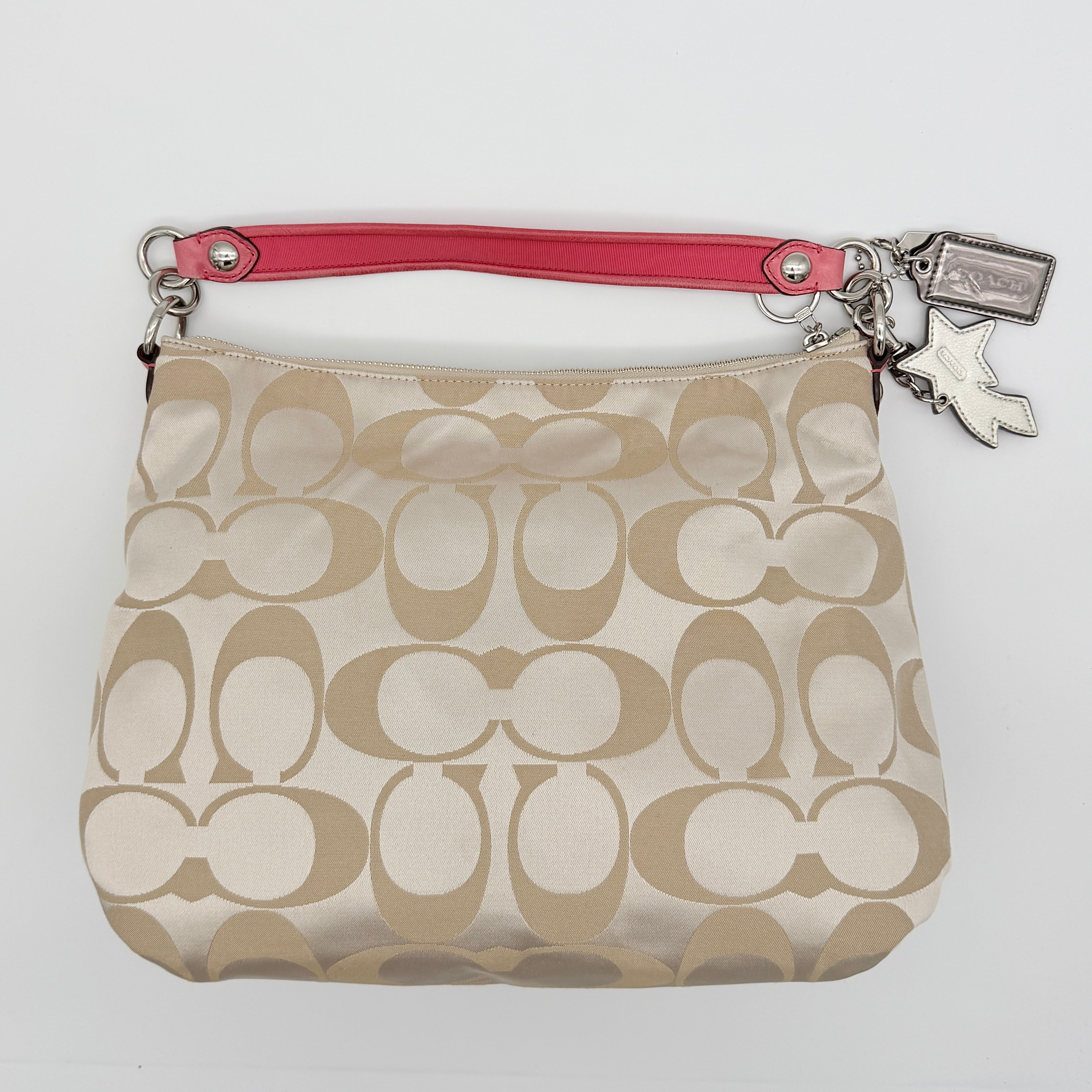 Coach Signature Poppy Pocket Hobo in beige sateen canvas with pink leather trim and silver hardware, front view with double pockets and charms.